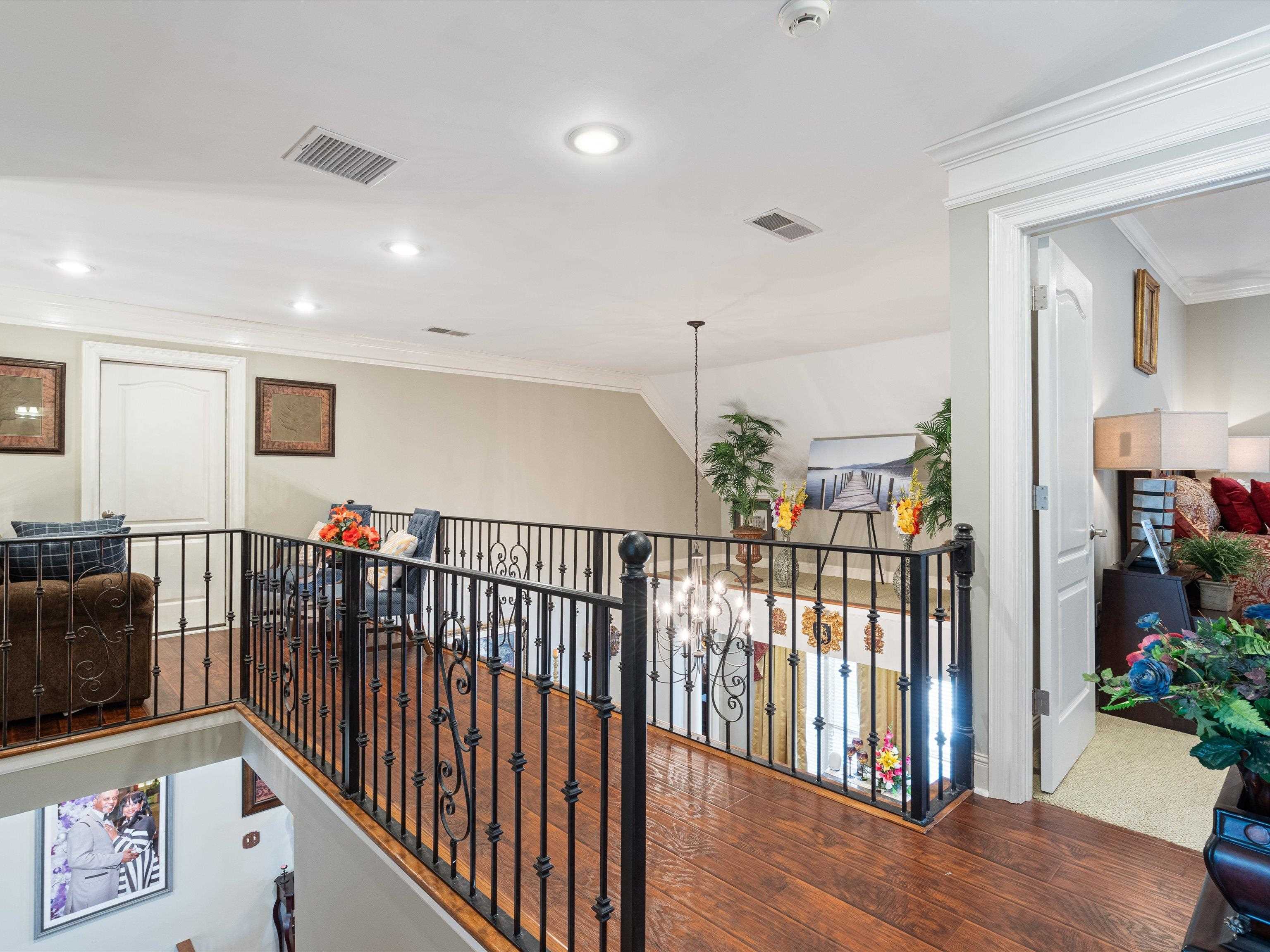 Corridor with wood-type flooring and ornamental molding