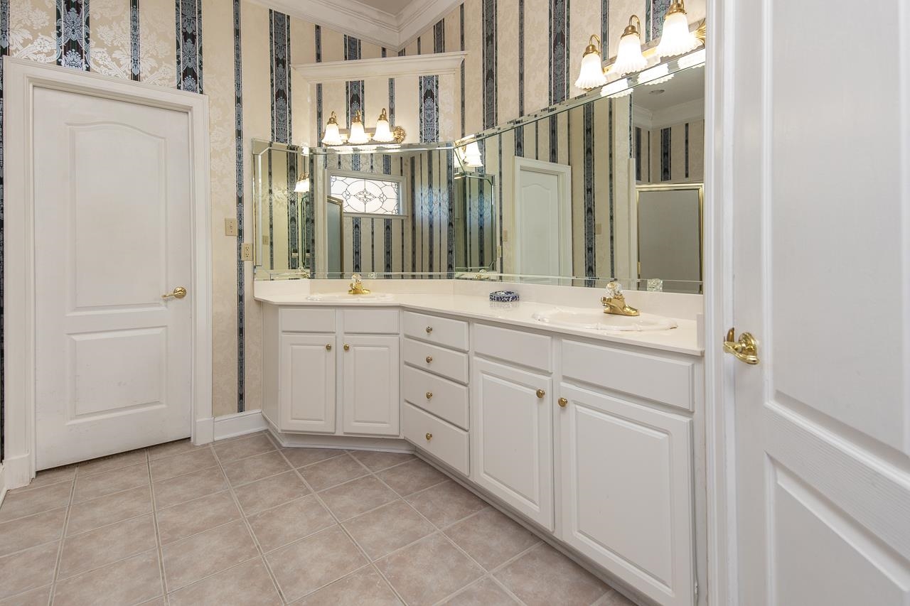 Bathroom featuring ornamental molding, tile patterned flooring, and vanity