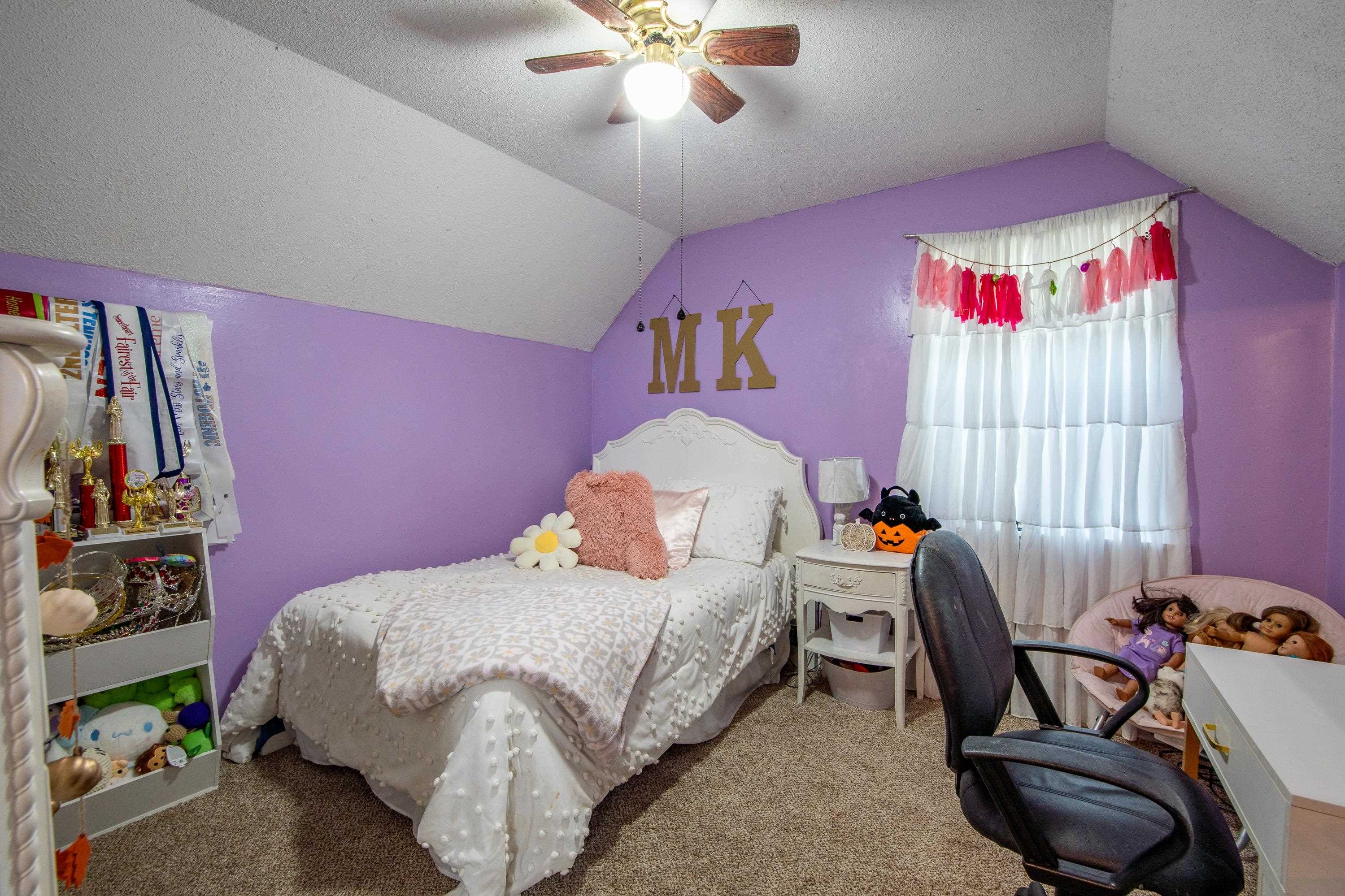 Carpeted bedroom featuring vaulted ceiling, ceiling fan, and a textured ceiling