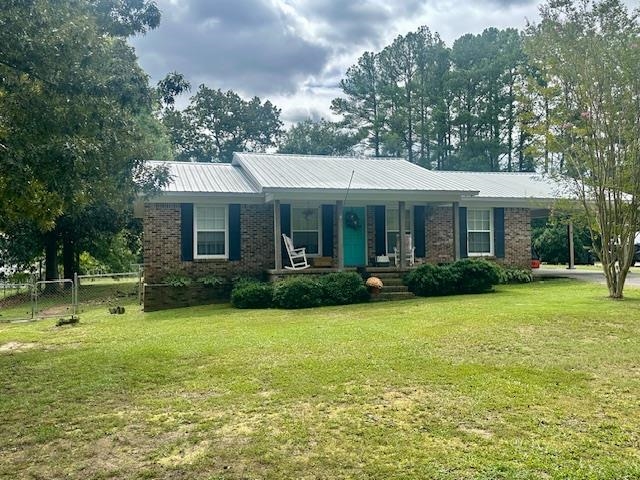 Single story home featuring a front lawn and a porch