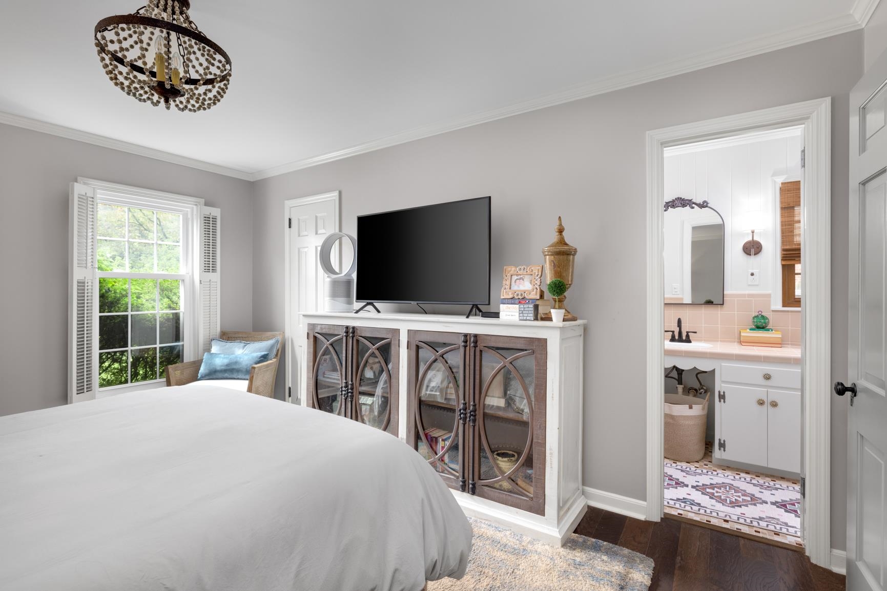 Bedroom featuring ornamental molding, ensuite bath, dark wood-type flooring, and sink