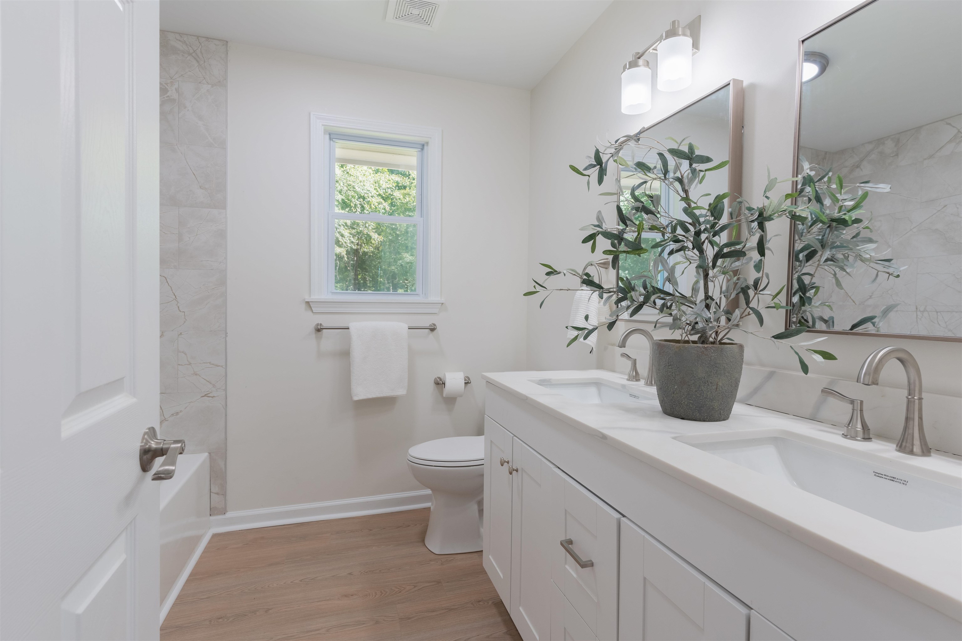 Full bathroom featuring hardwood / wood-style floors, vanity, toilet, and tiled shower / bath combo