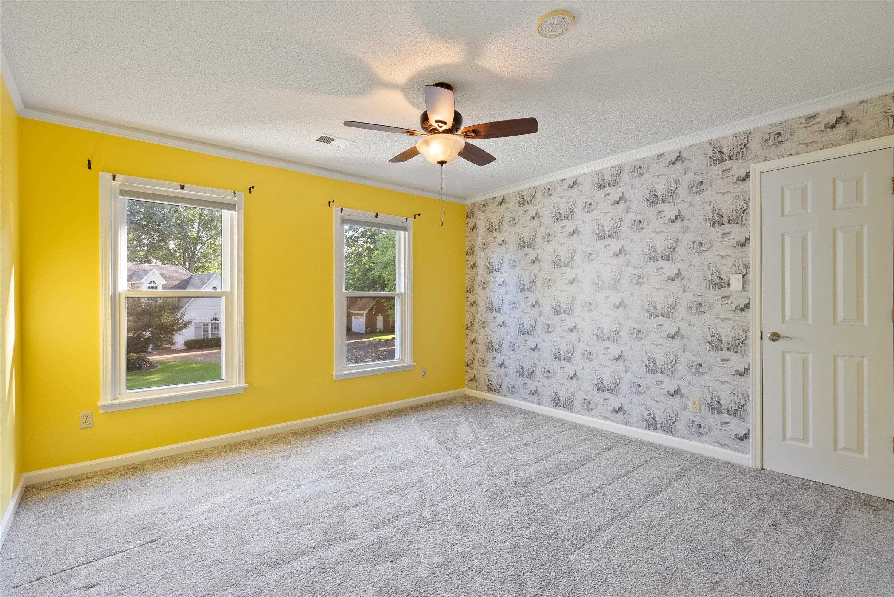 Spare room featuring ceiling fan, crown molding, carpet flooring, and a textured ceiling