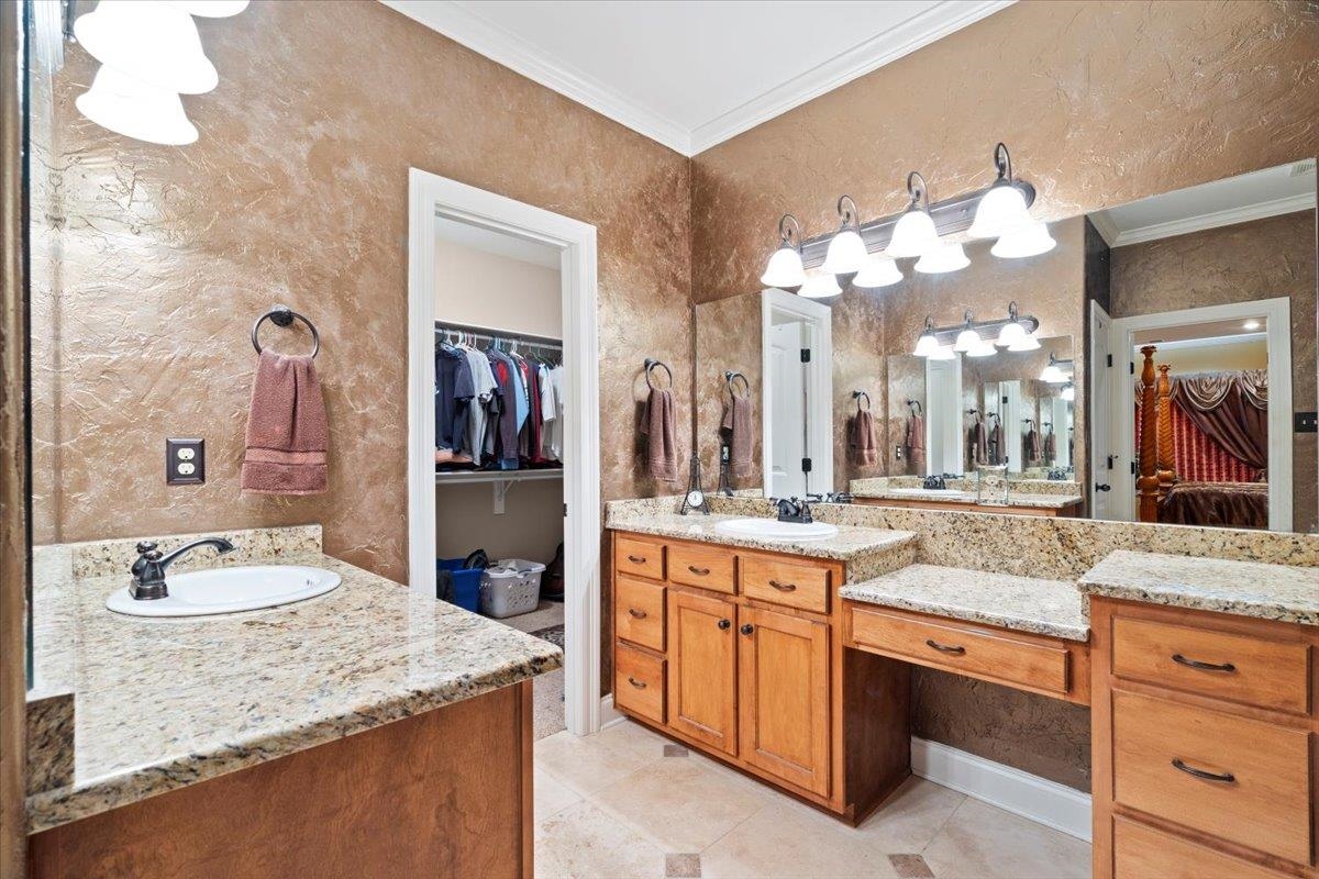 Bathroom featuring vanity, ornamental molding, and tile patterned floors