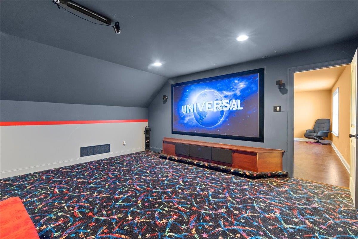 Home theater with carpet and lofted ceiling