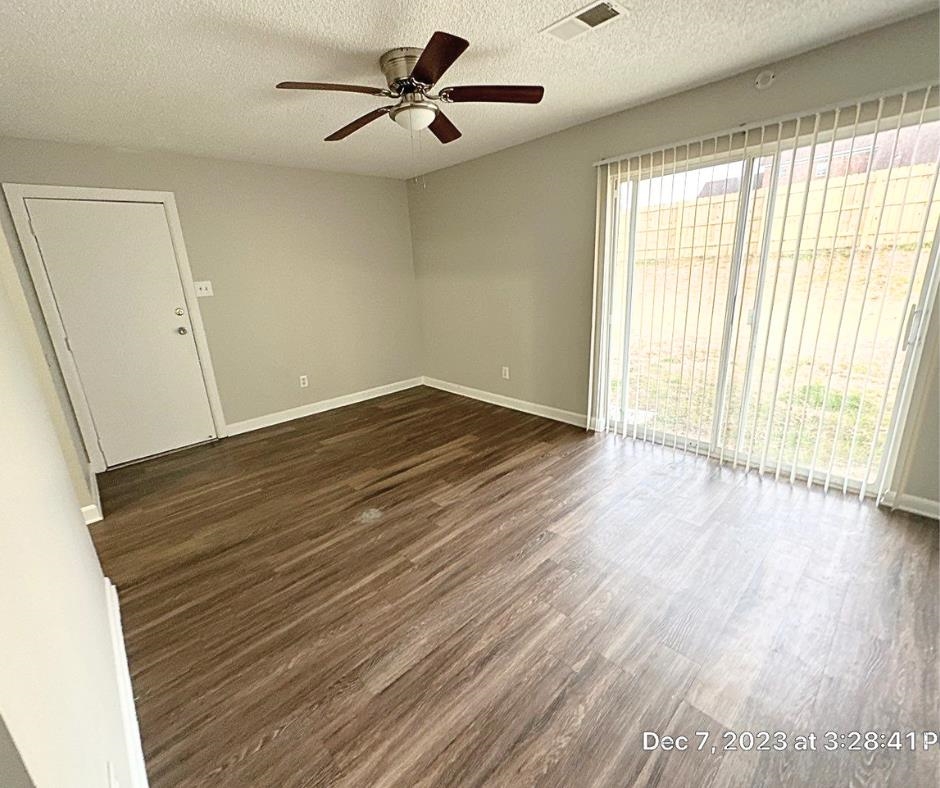 Unfurnished room featuring a textured ceiling, dark hardwood / wood-style flooring, and ceiling fan