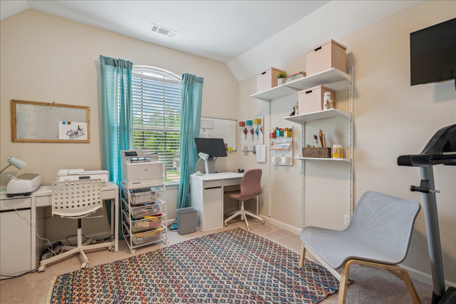 Carpeted home office featuring vaulted ceiling