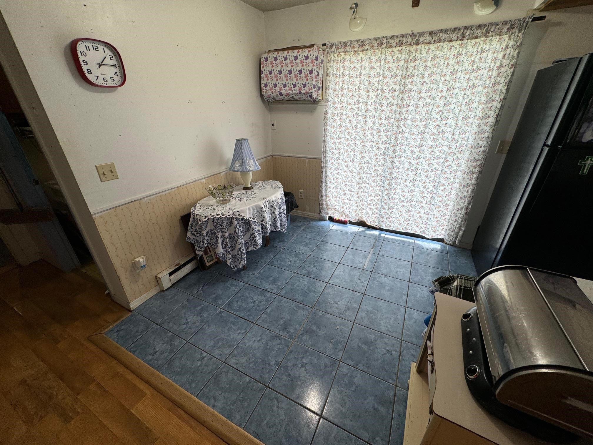 Dining room with a baseboard radiator and dark wood-type flooring