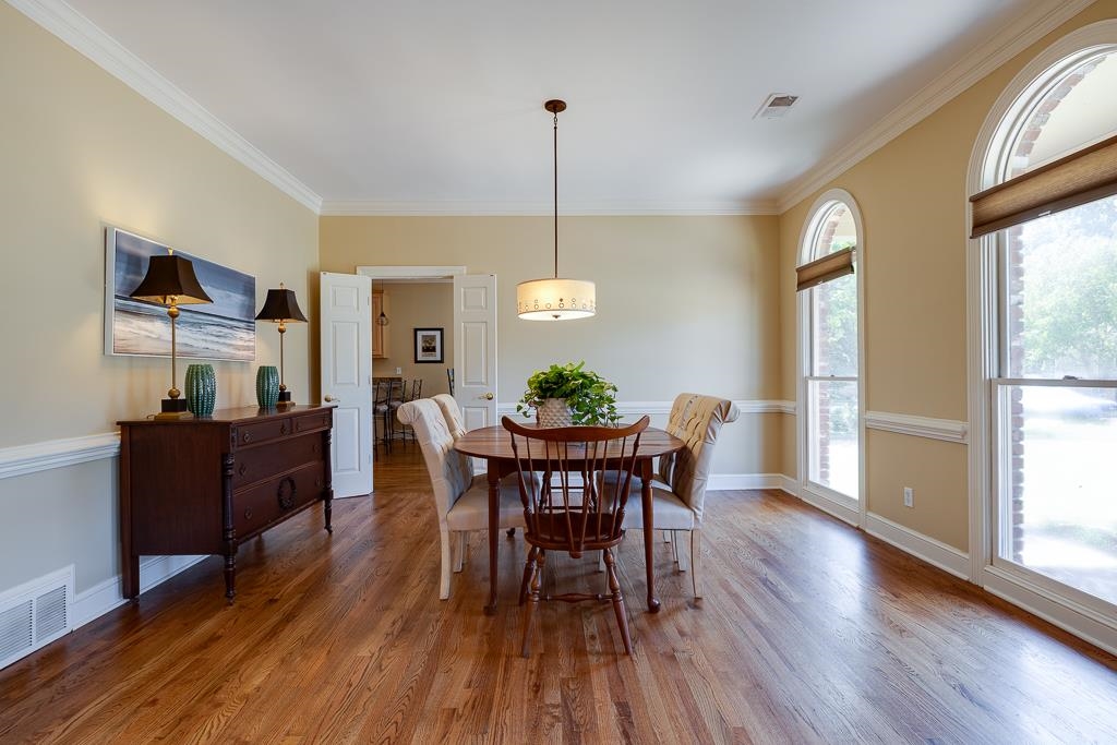 Dining area with ornamental molding, hardwood / wood-style floors, and a wealth of natural light