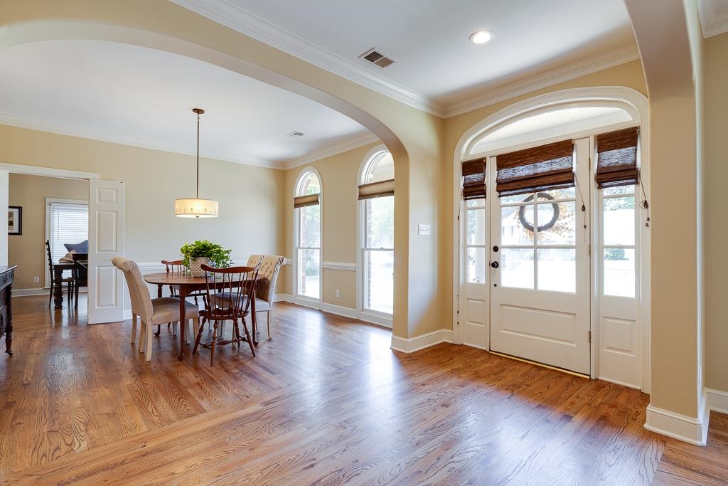 Entrance foyer with light hardwood / wood-style flooring, plenty of natural light, and crown molding