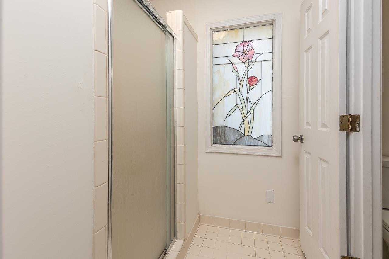 Bathroom with walk in shower, toilet, and tile patterned floors