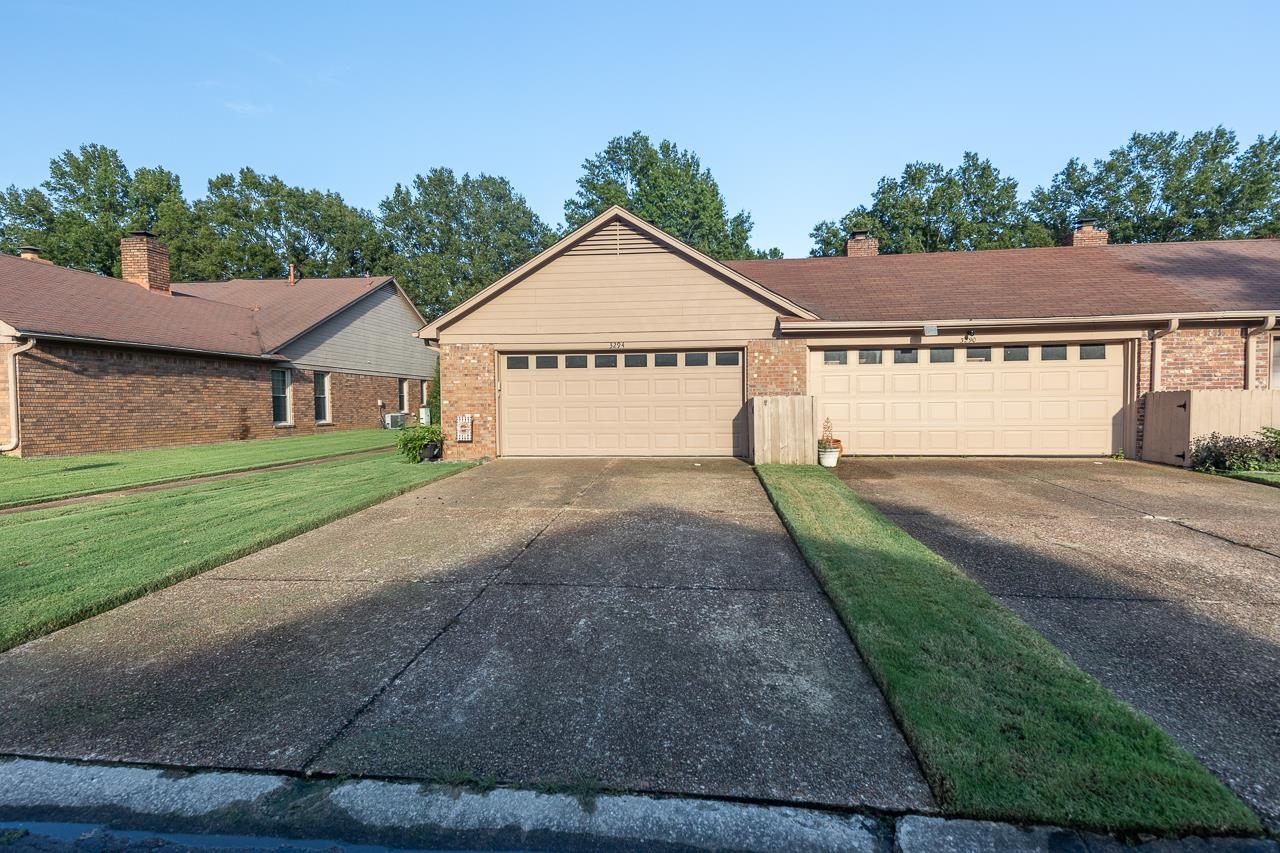 Ranch-style home featuring a front yard and a garage