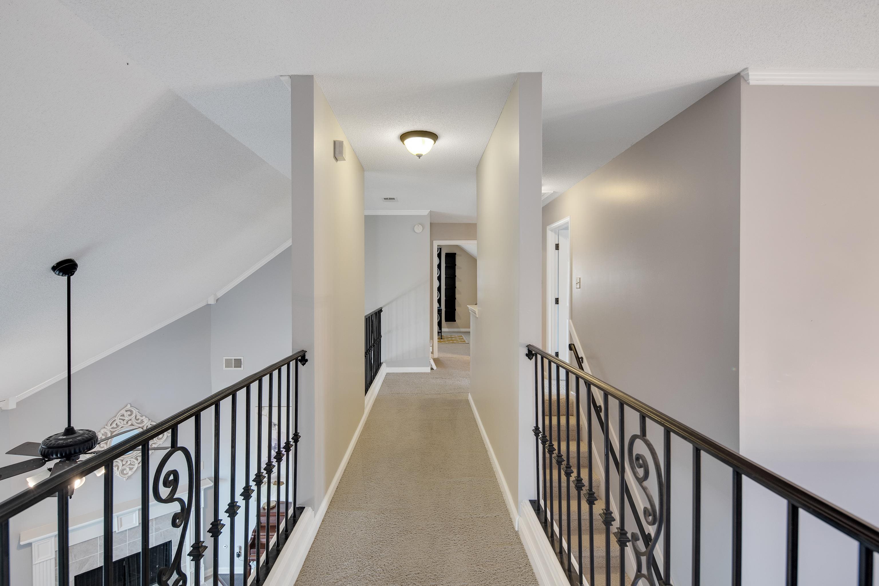 Corridor featuring light colored carpet