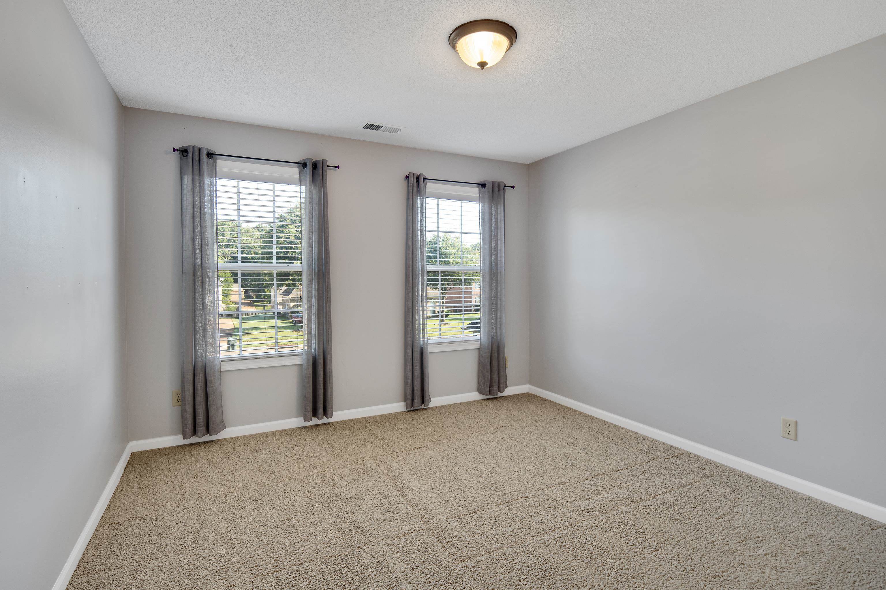 Unfurnished room with a textured ceiling, carpet flooring, and plenty of natural light