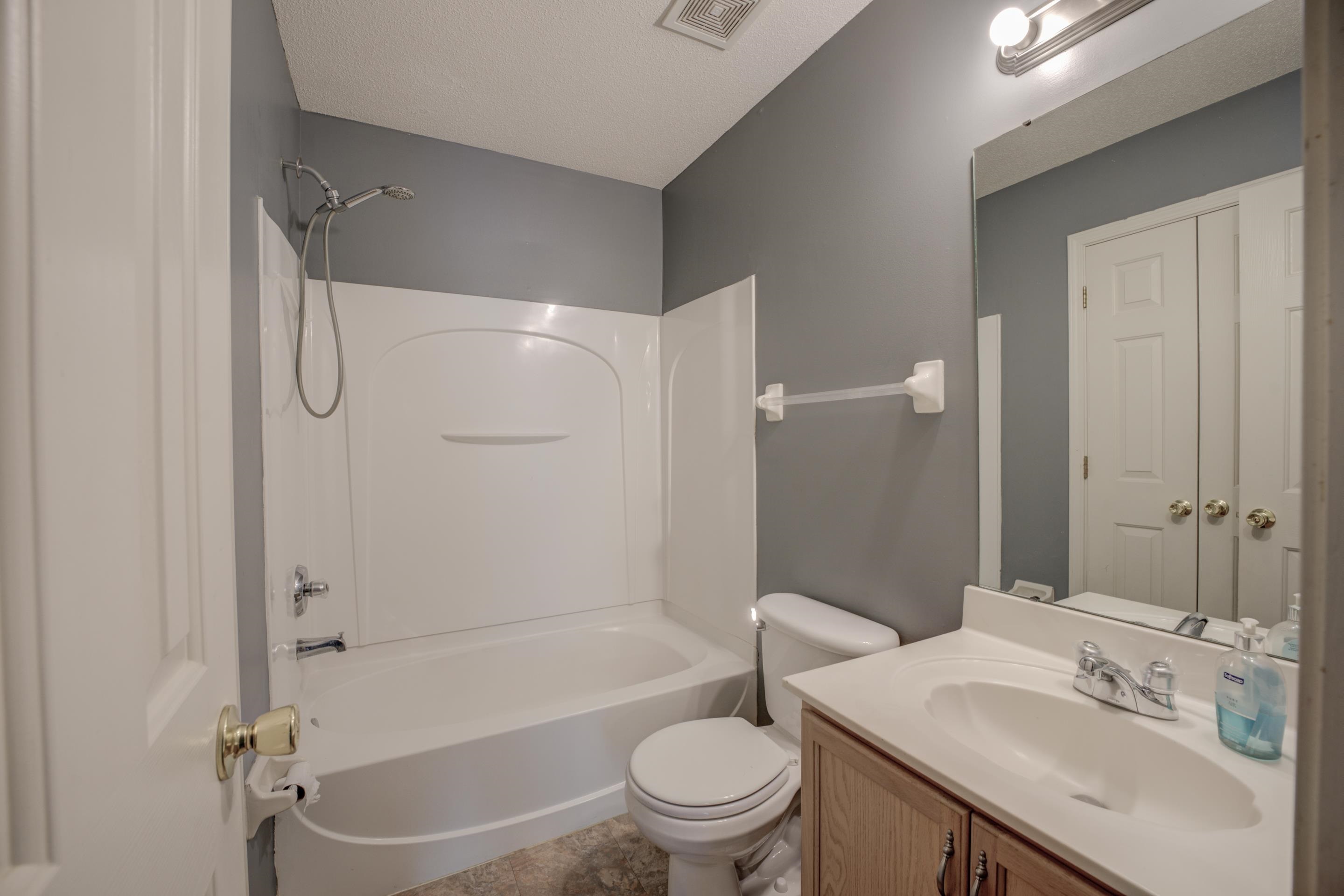 Full bathroom with vanity, bathtub / shower combination, toilet, and a textured ceiling