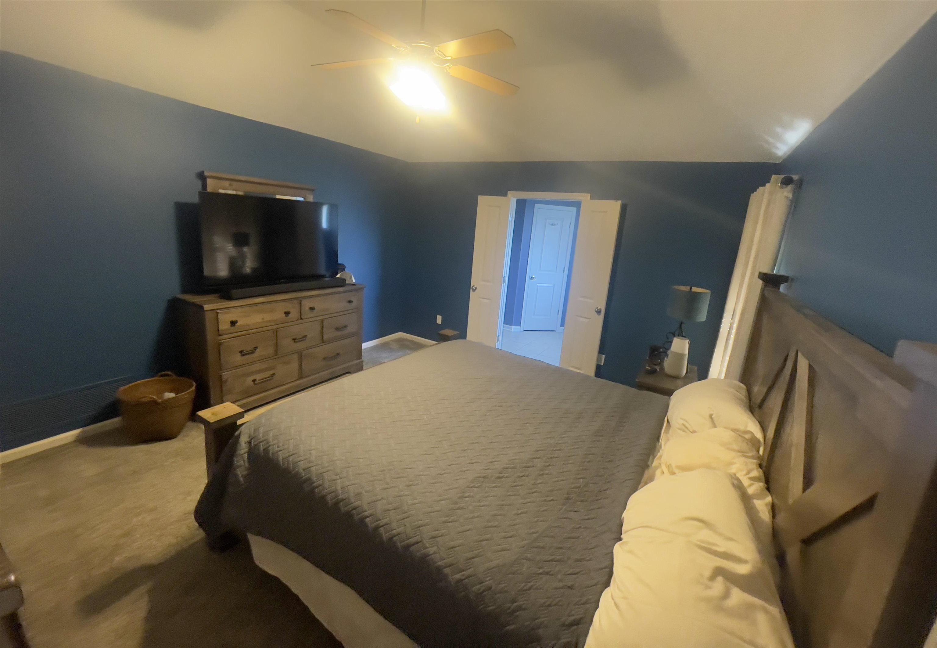 Bedroom with lofted ceiling, carpet flooring, and ceiling fan