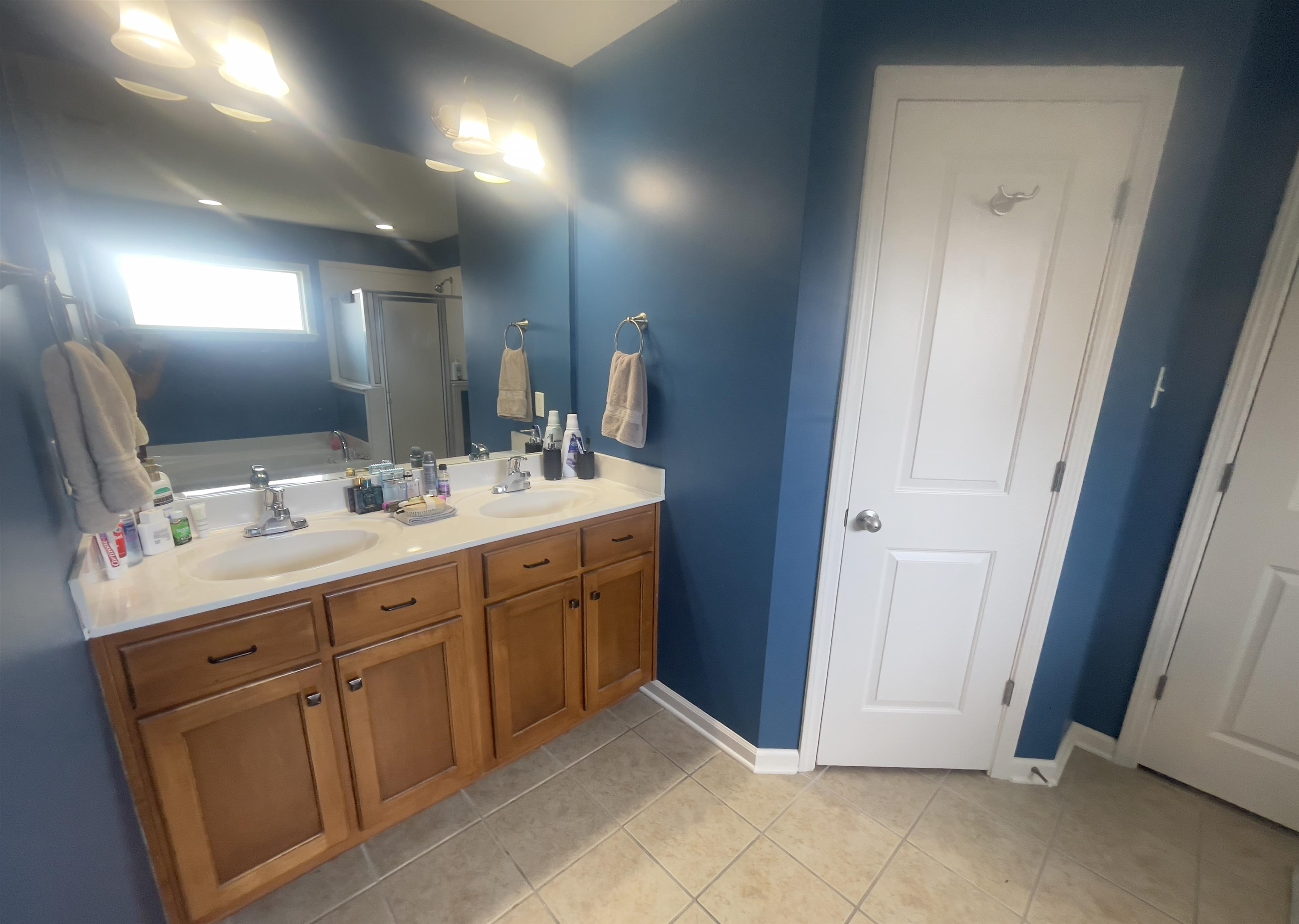 Bathroom with tile patterned flooring, independent shower and bath, and vanity