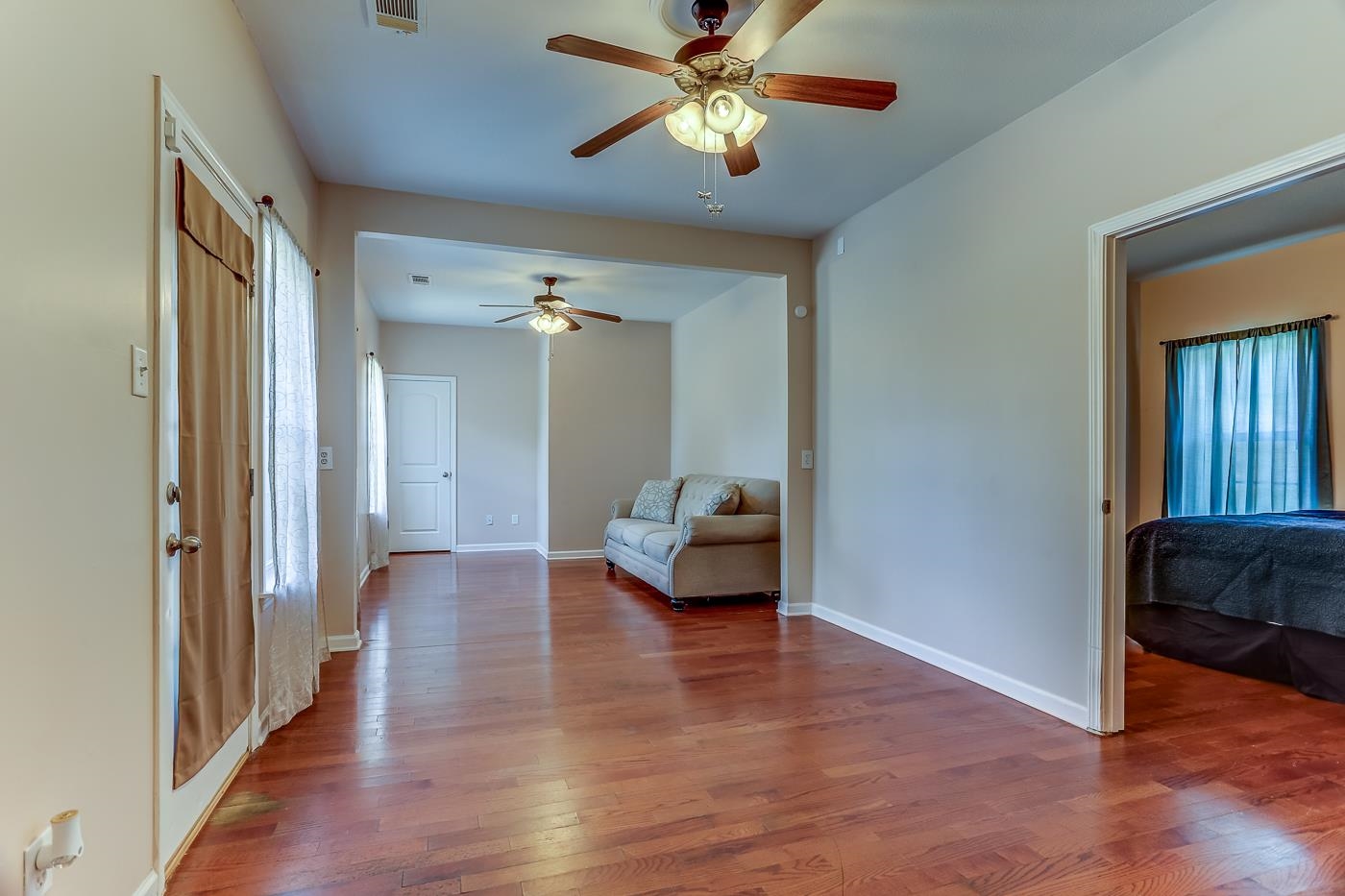 Interior space with a wealth of natural light, ceiling fan, and hardwood