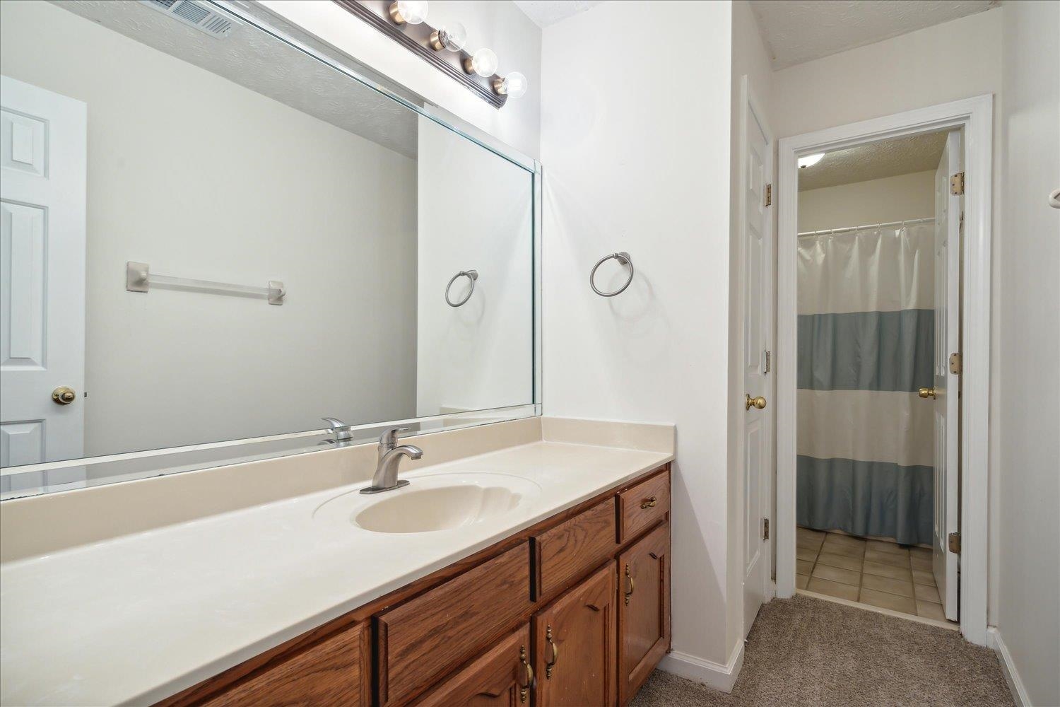 Bathroom featuring a textured ceiling, tile patterned flooring, and vanity