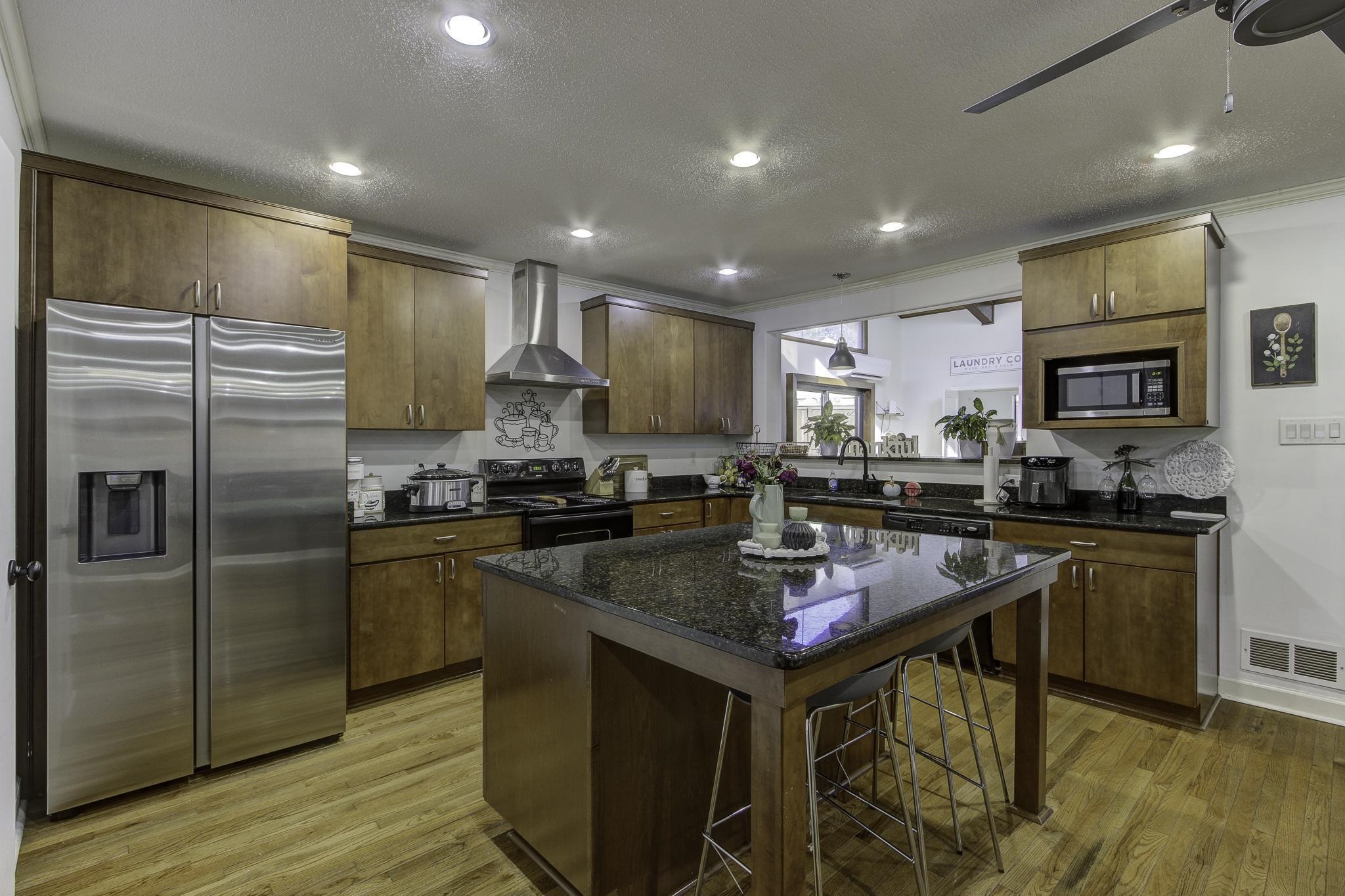 The beautiful new kitchen features custom cabinetry, abundance granite counter space, the original solid oak hardwoods, a pantry & more!