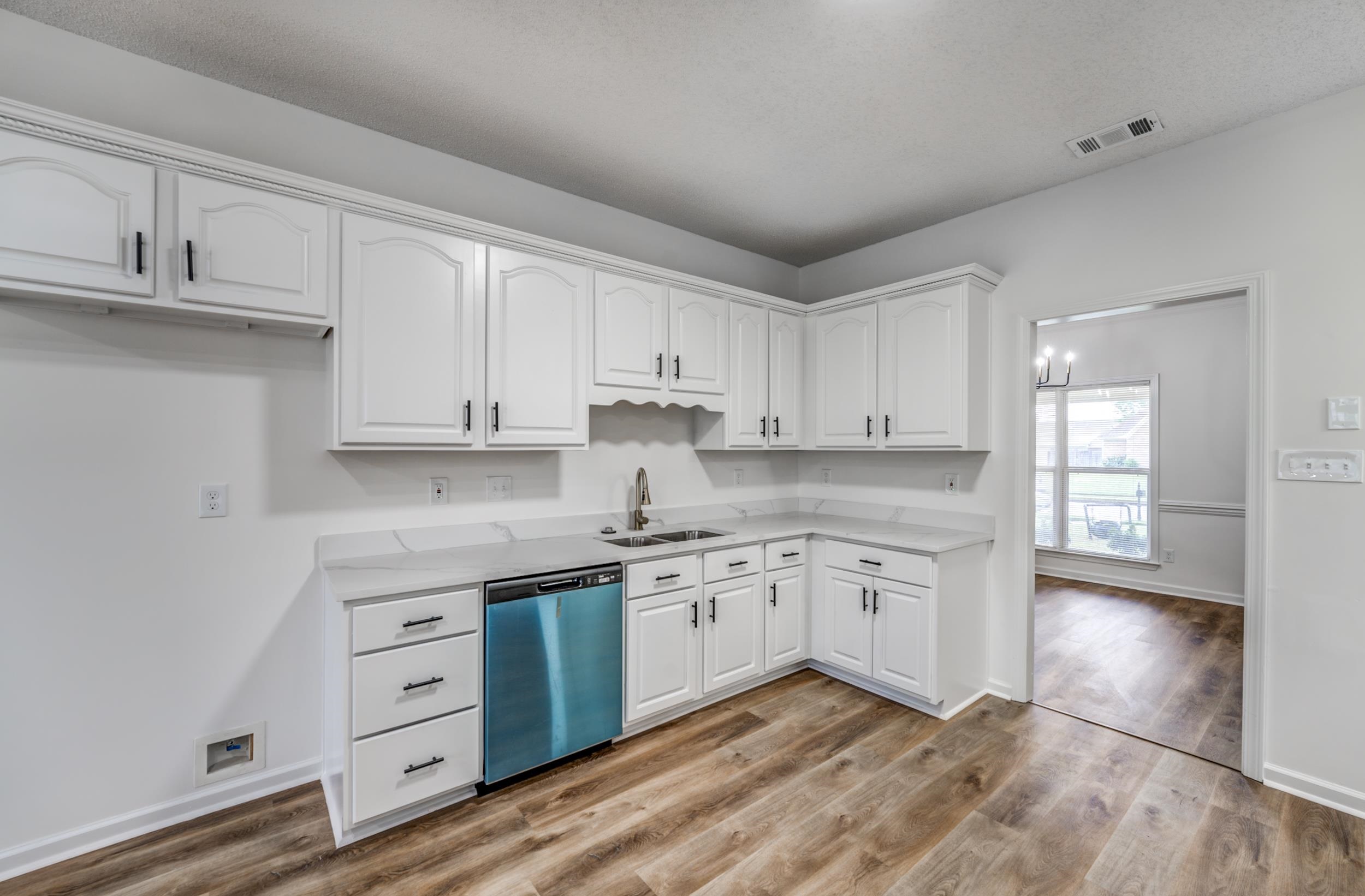 Kitchen featuring white cabinets, light hardwood / wood-style flooring, sink, and stainless steel dishwasher