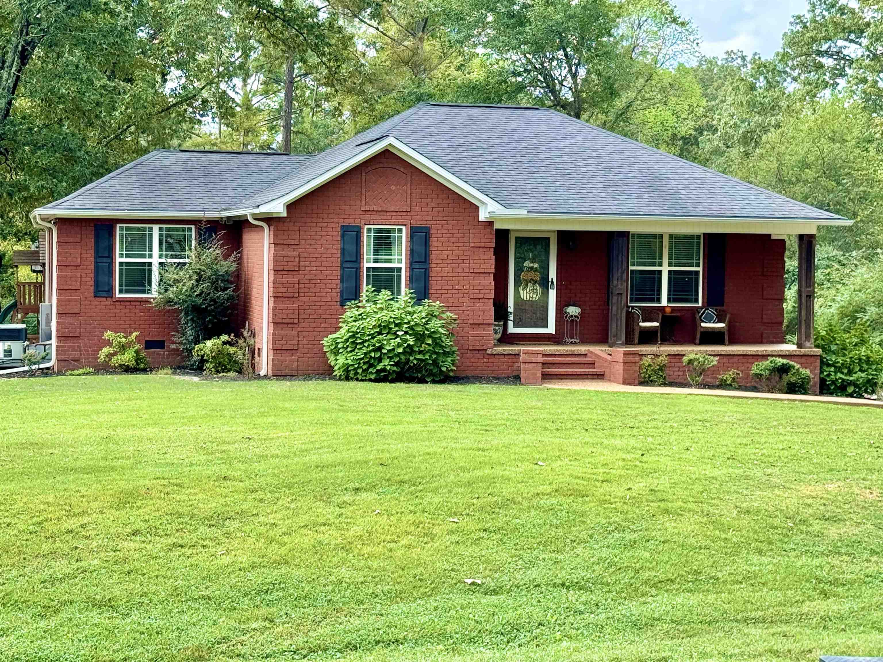 Ranch-style home with a front lawn and covered porch