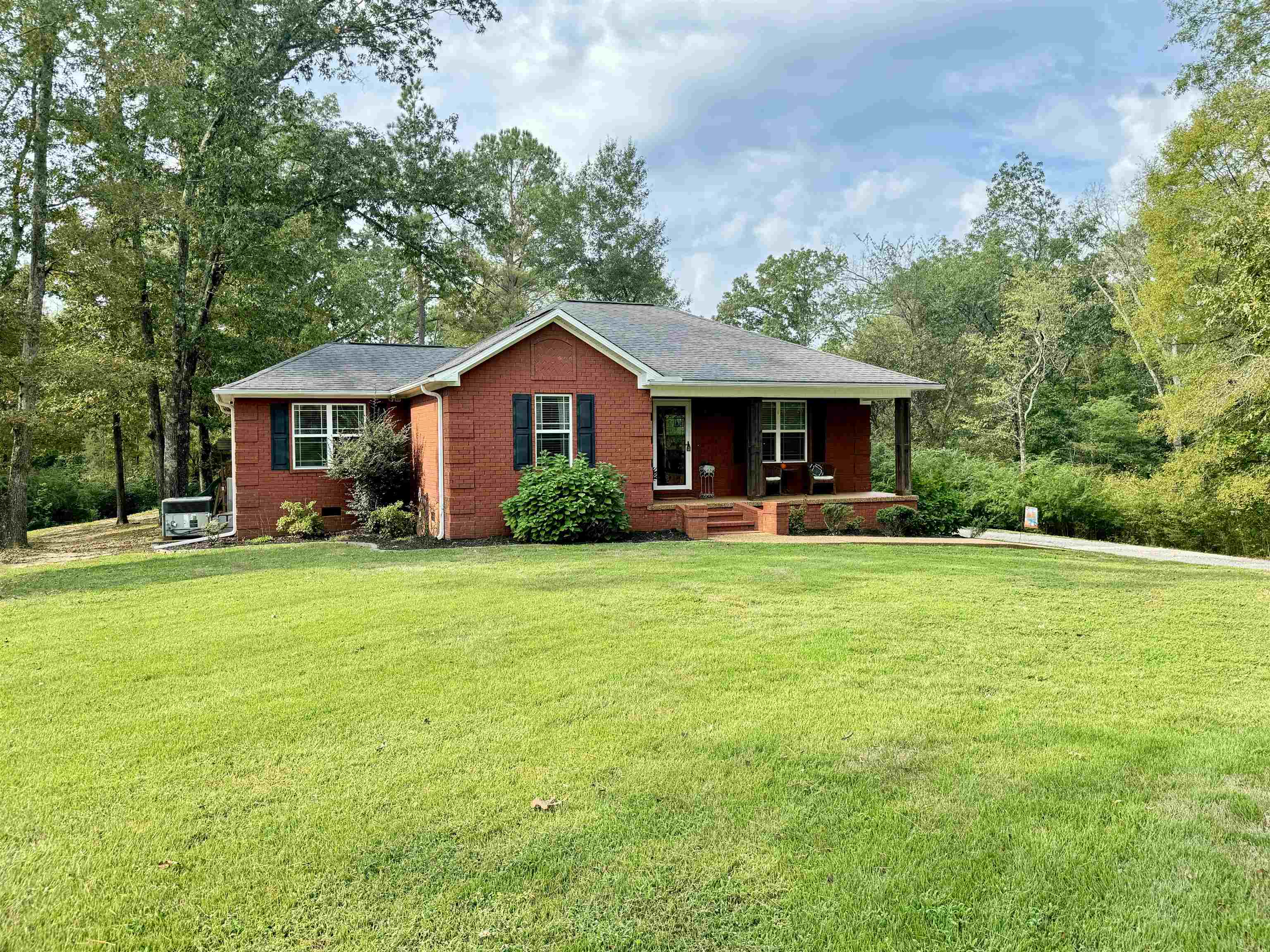 Ranch-style house with a front yard and covered porch