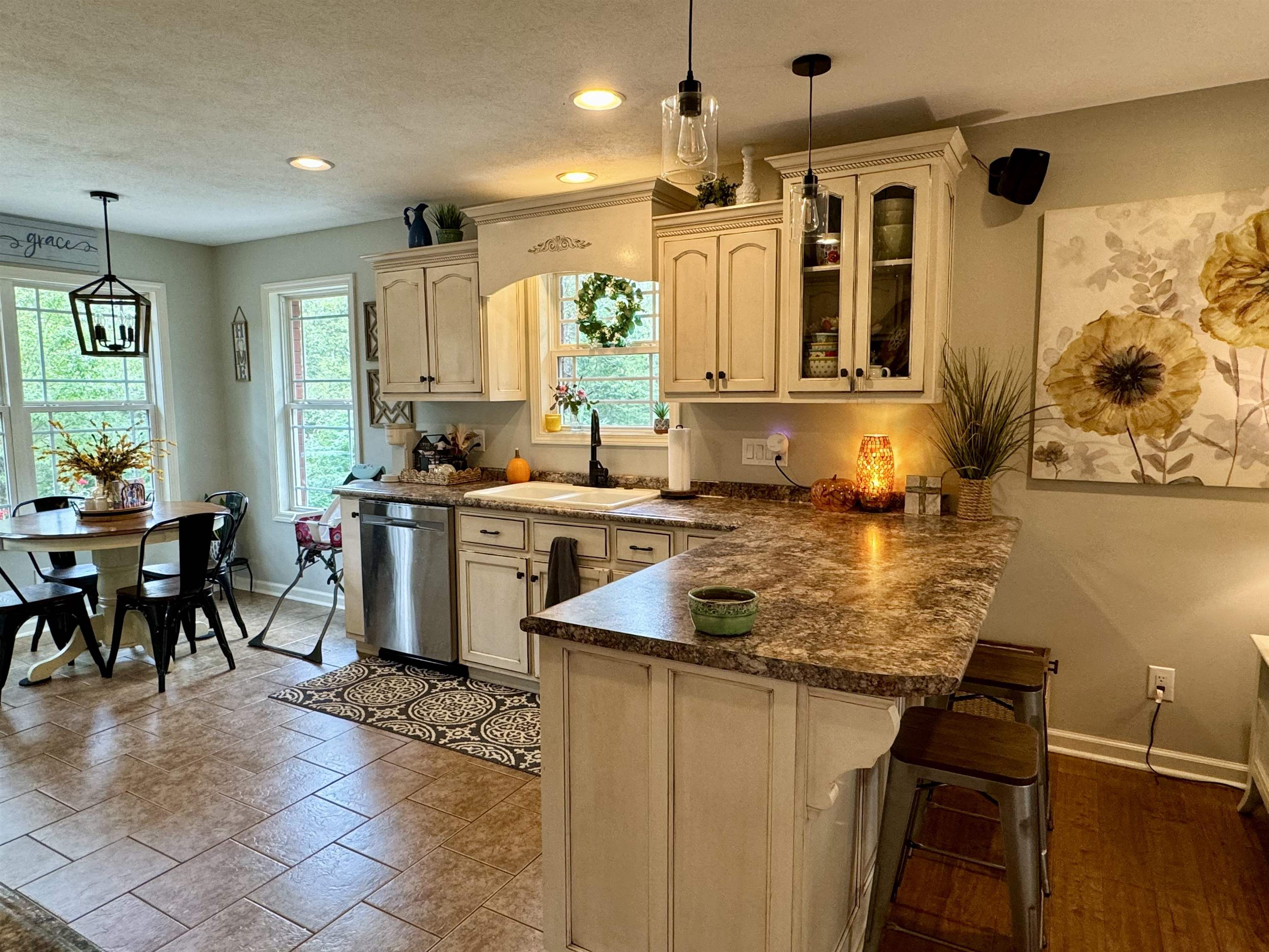 Kitchen with pendant lighting, plenty of natural light, sink, and stainless steel dishwasher