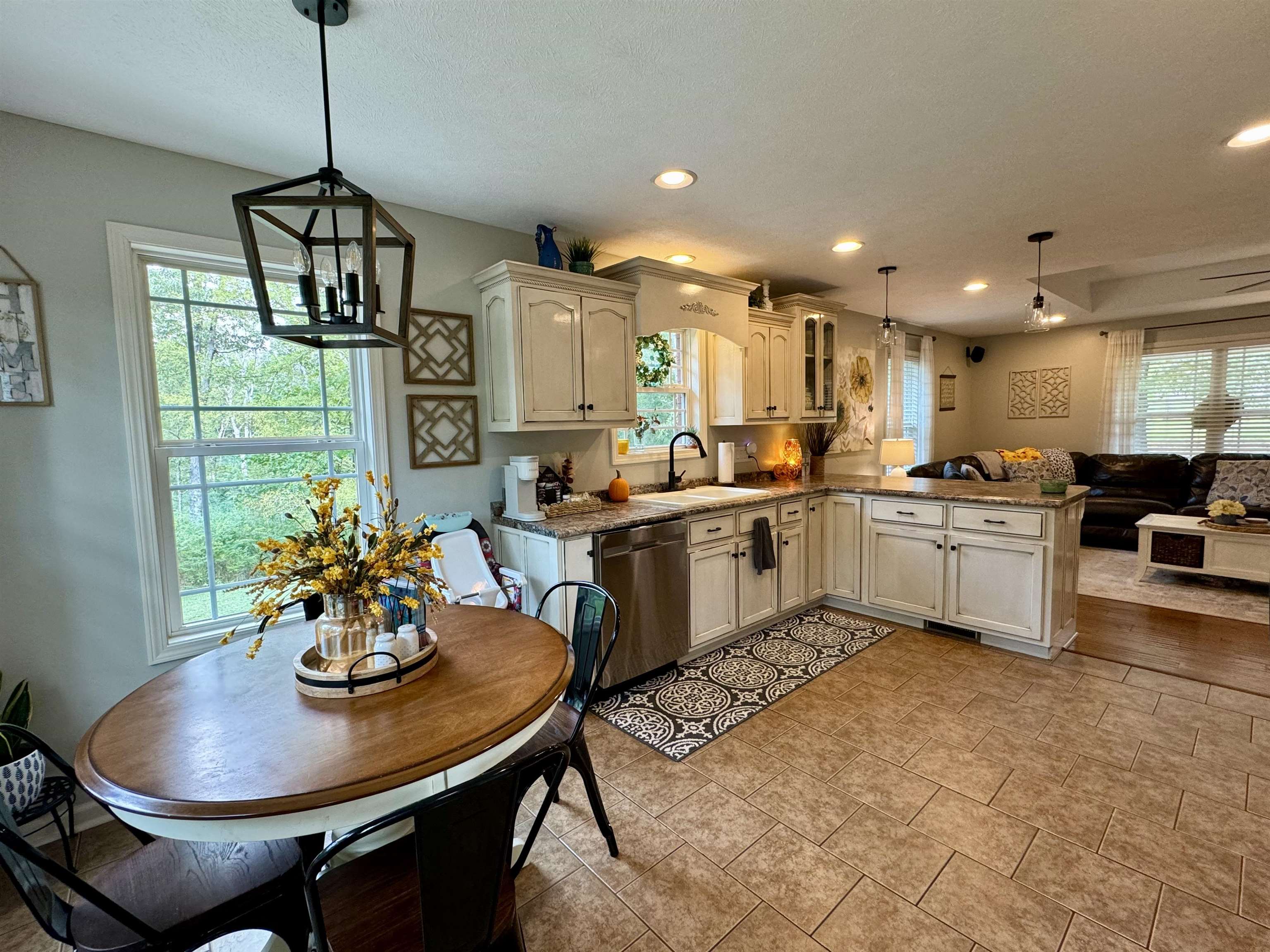 Kitchen featuring hanging light fixtures, a healthy amount of sunlight, kitchen peninsula, and dishwasher