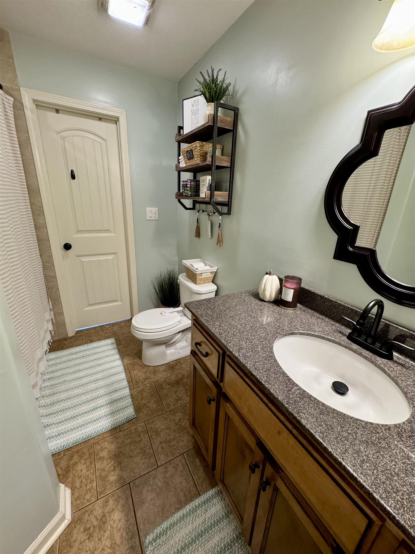 Bathroom with vanity, toilet, and tile patterned floors
