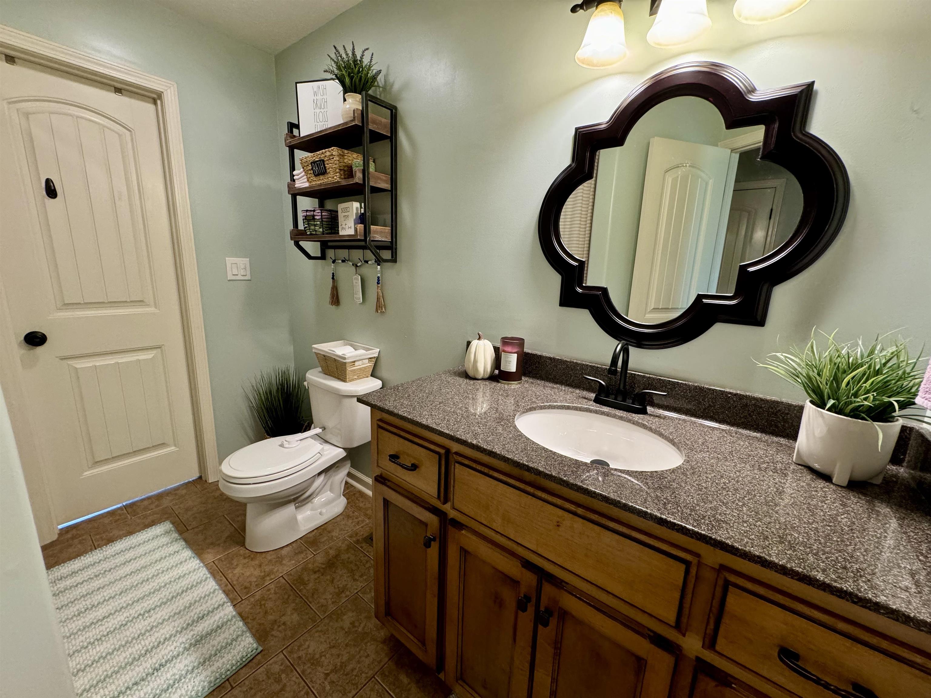 Bathroom with tile patterned floors, vanity, and toilet