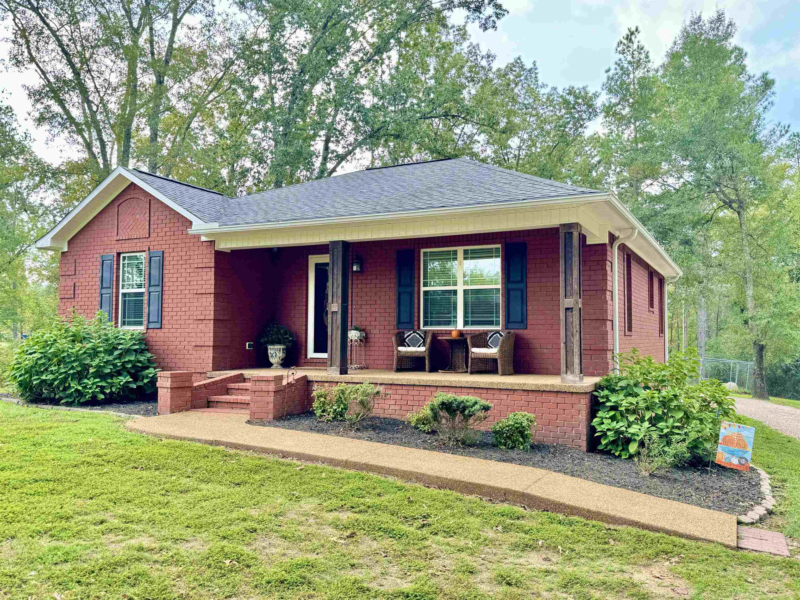 Ranch-style home featuring a porch and a front lawn