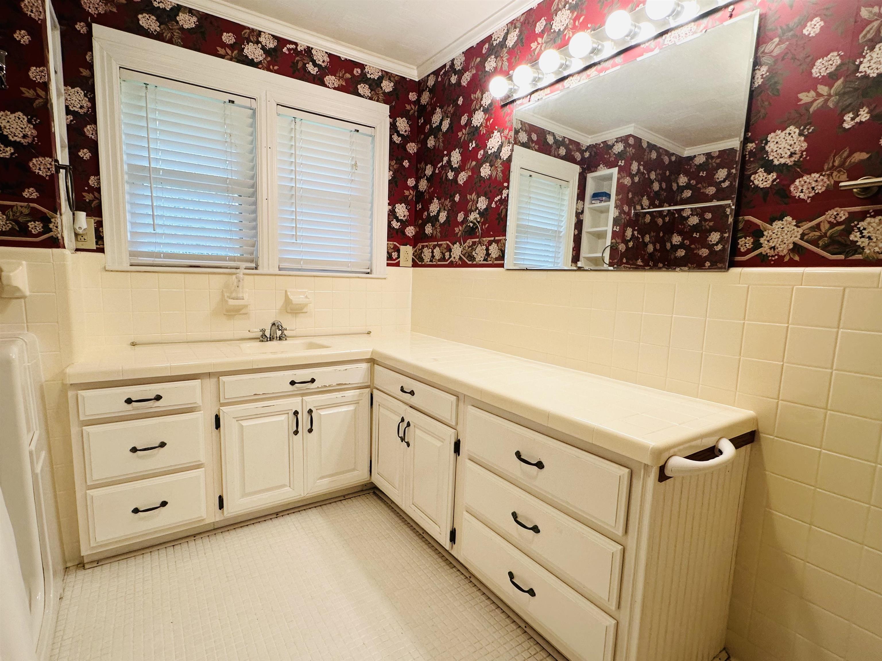 Bathroom with vanity, tile walls, and crown molding