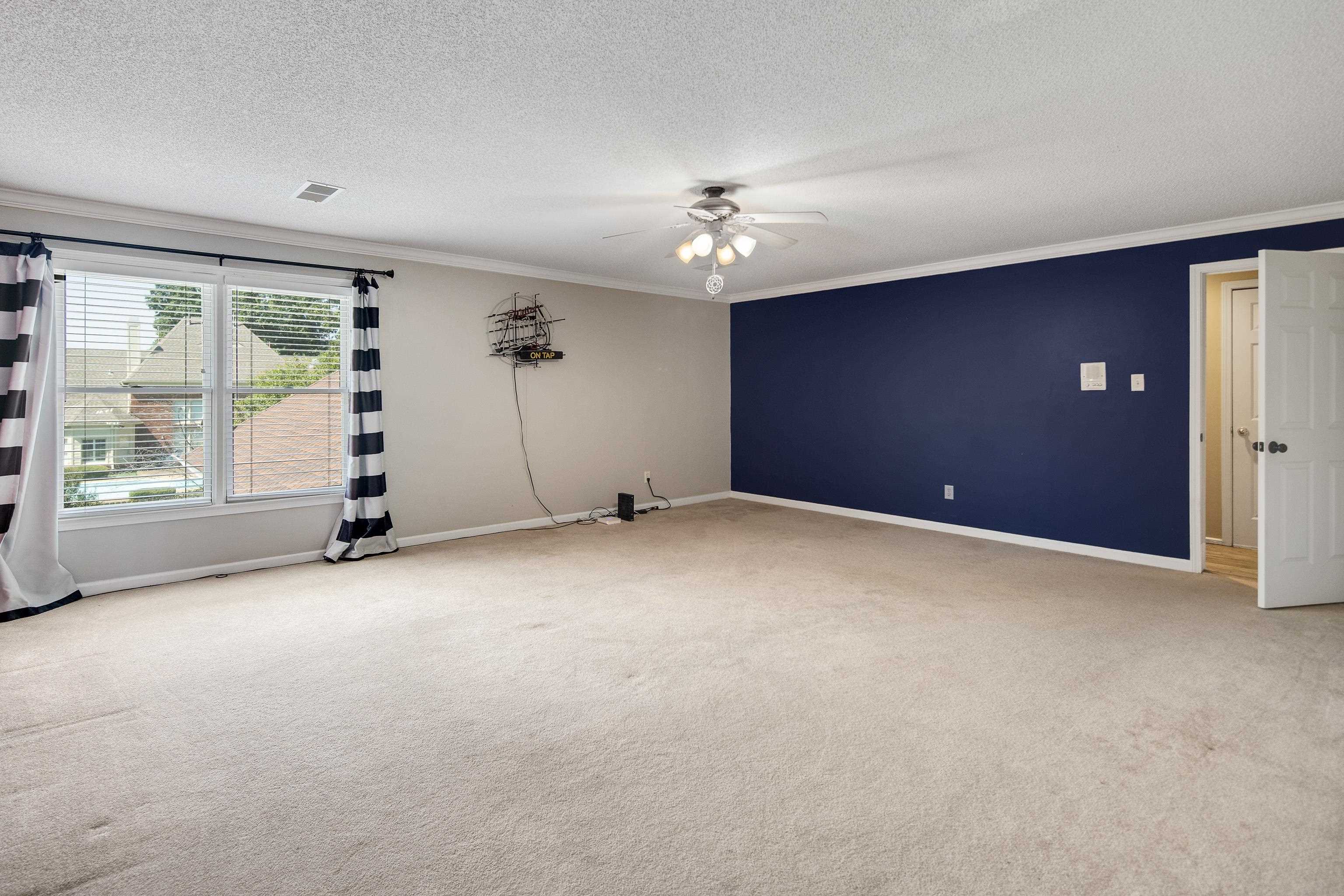 Carpeted spare room with ceiling fan, a textured ceiling, and ornamental molding