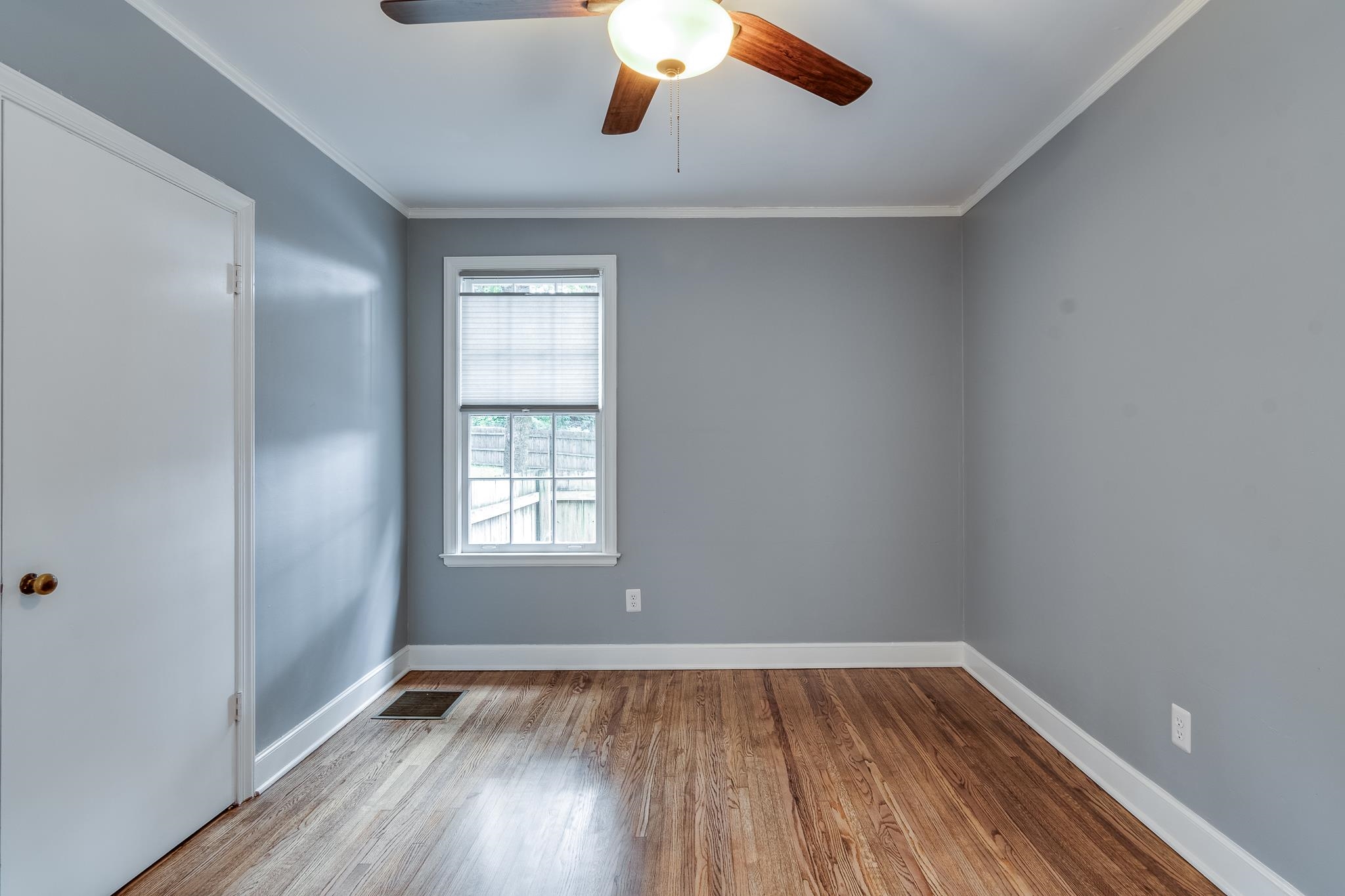 Empty room featuring ornamental molding, hardwood / wood-style floors, and ceiling fan