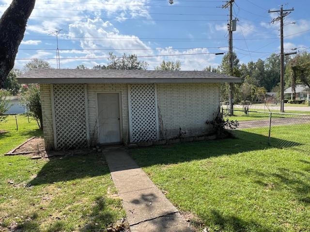 View of outdoor structure featuring a yard