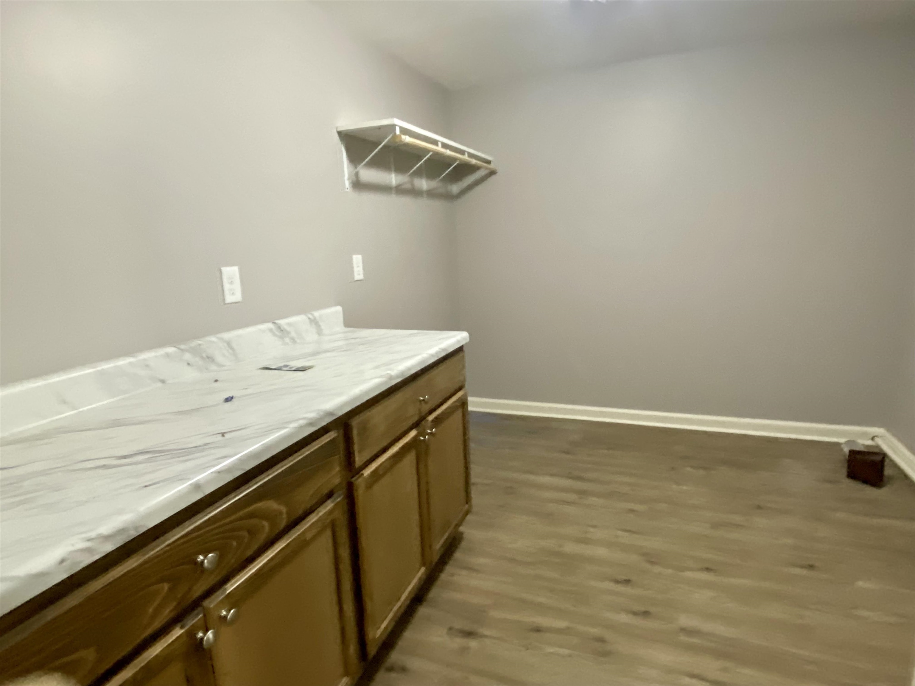 Laundry area featuring dark hardwood / wood-style floors. Lots of storage space. Hot water heater.