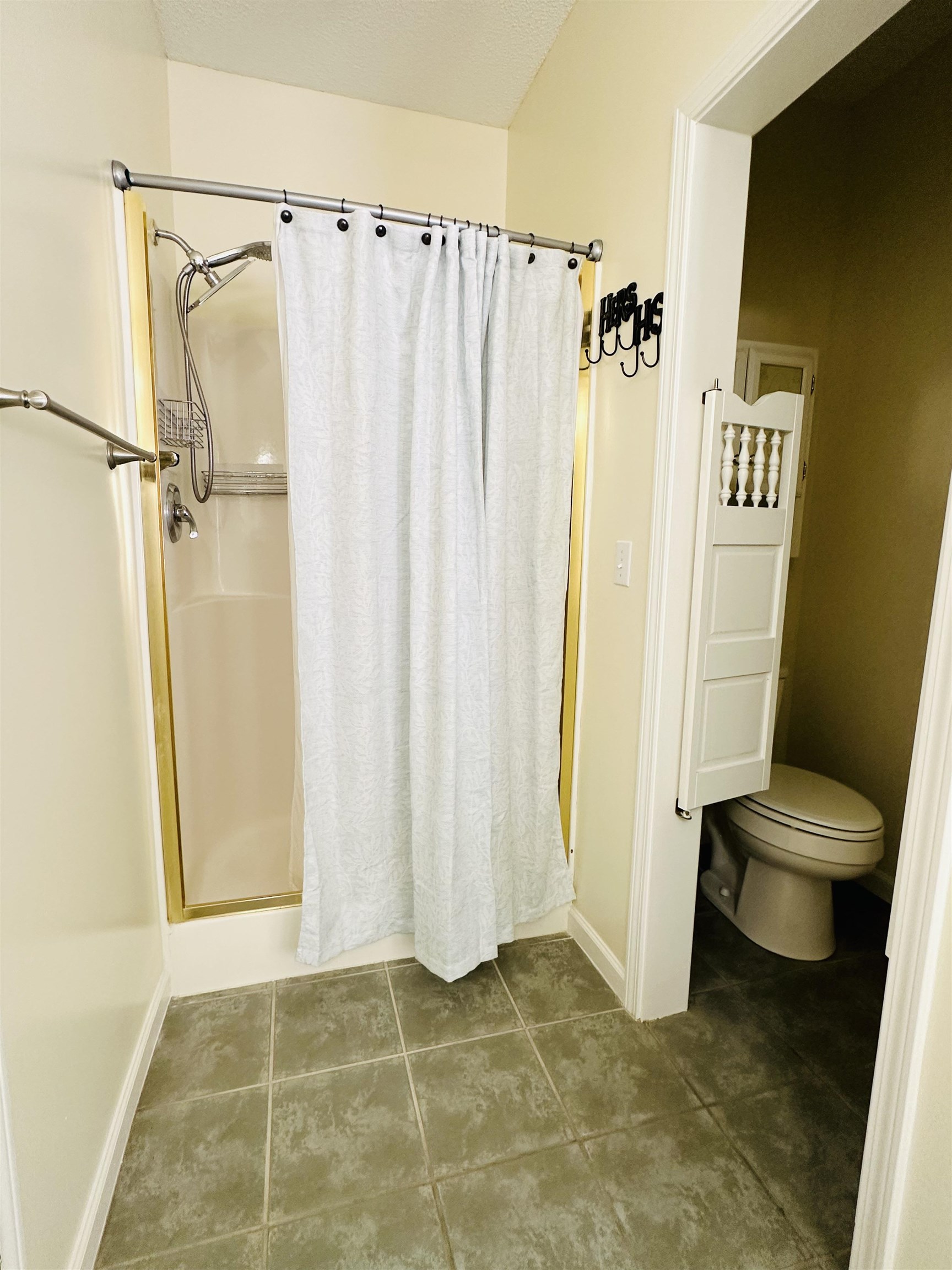 Bathroom with tile patterned flooring, toilet, and a shower with shower curtain