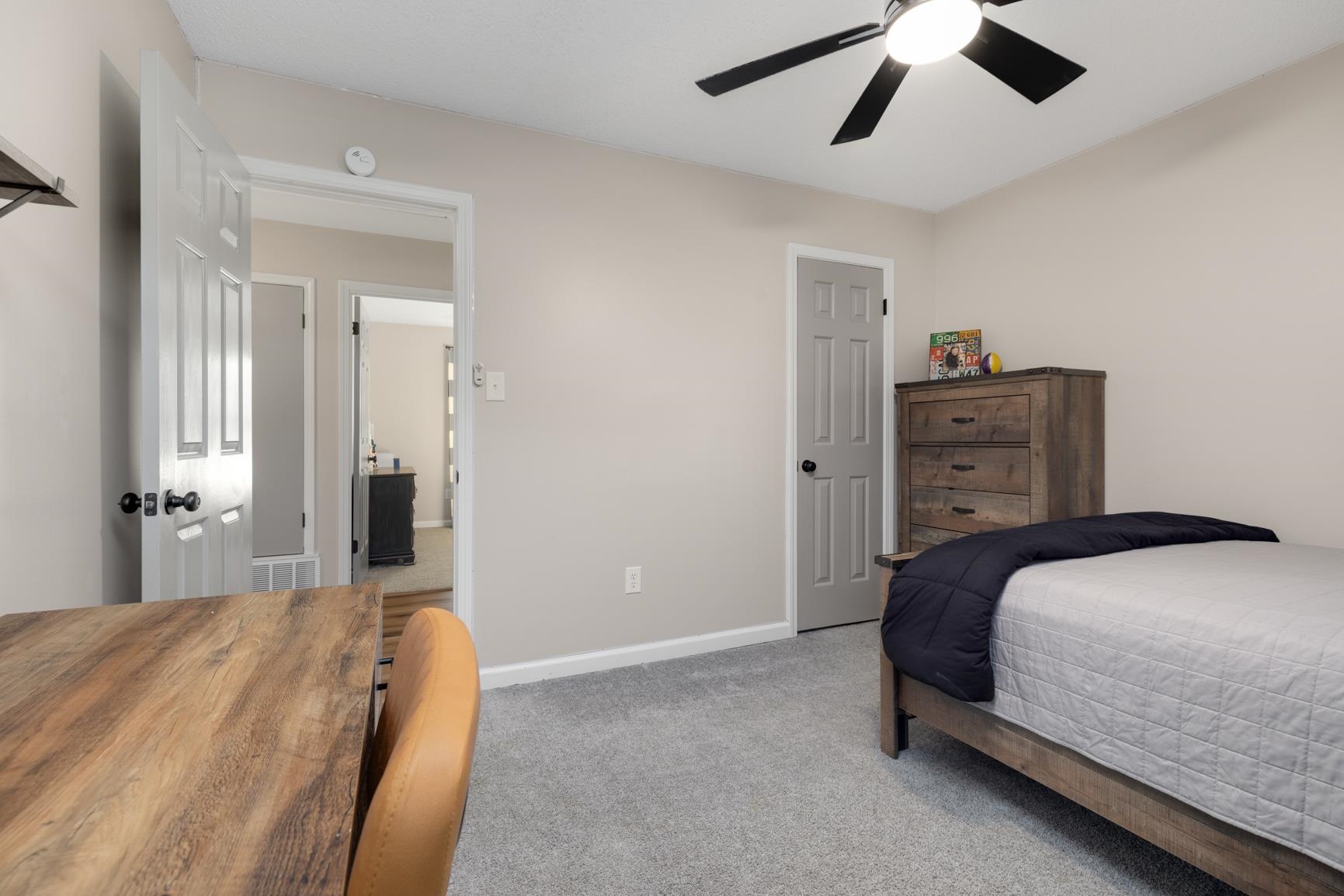 Carpeted bedroom featuring ceiling fan