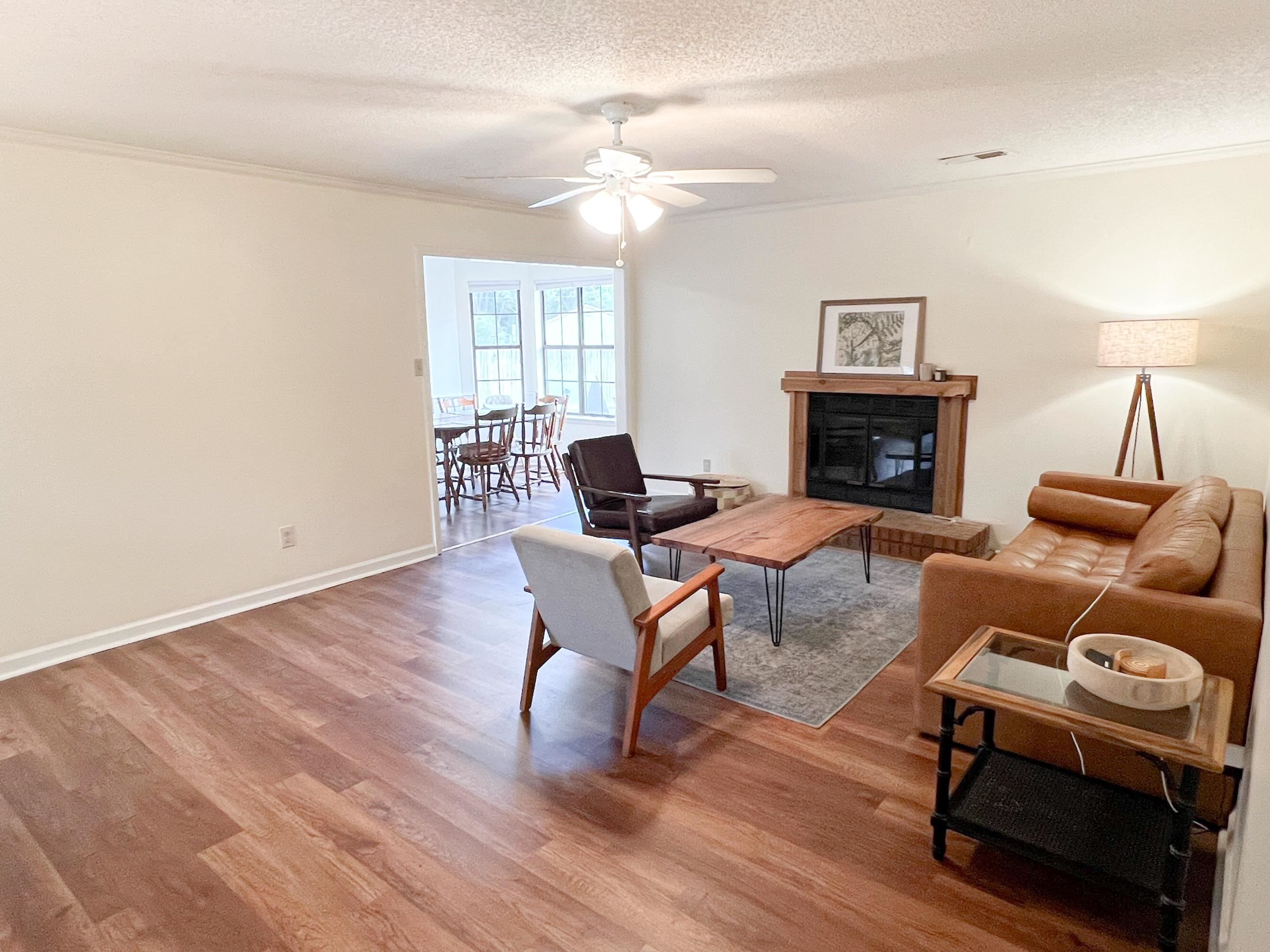 Living room featuring a textured ceiling, crown molding, hardwood / wood-style floors, and ceiling fan