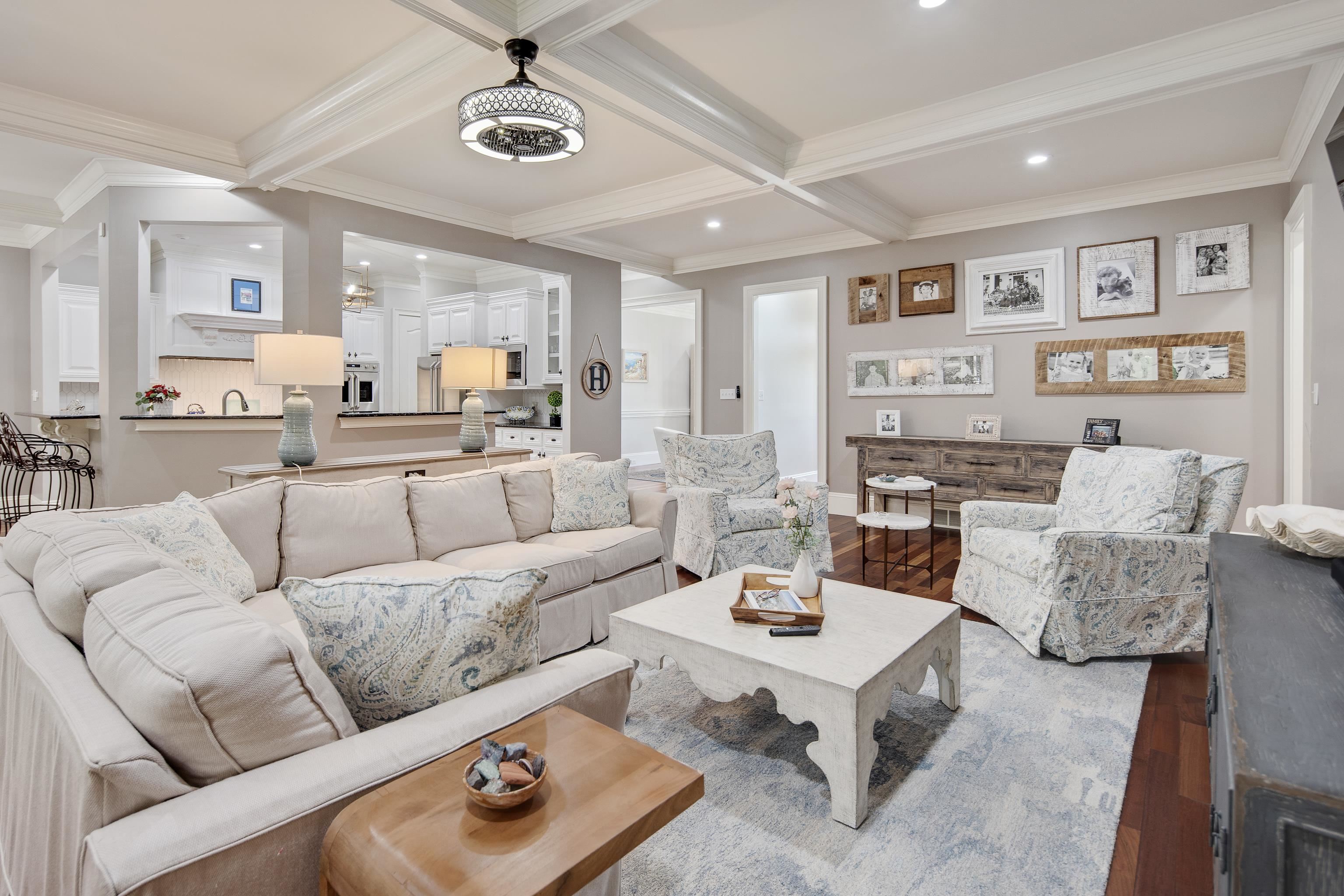 Living room featuring ornamental molding, coffered ceiling, beamed ceiling, and hardwood / wood-style floors