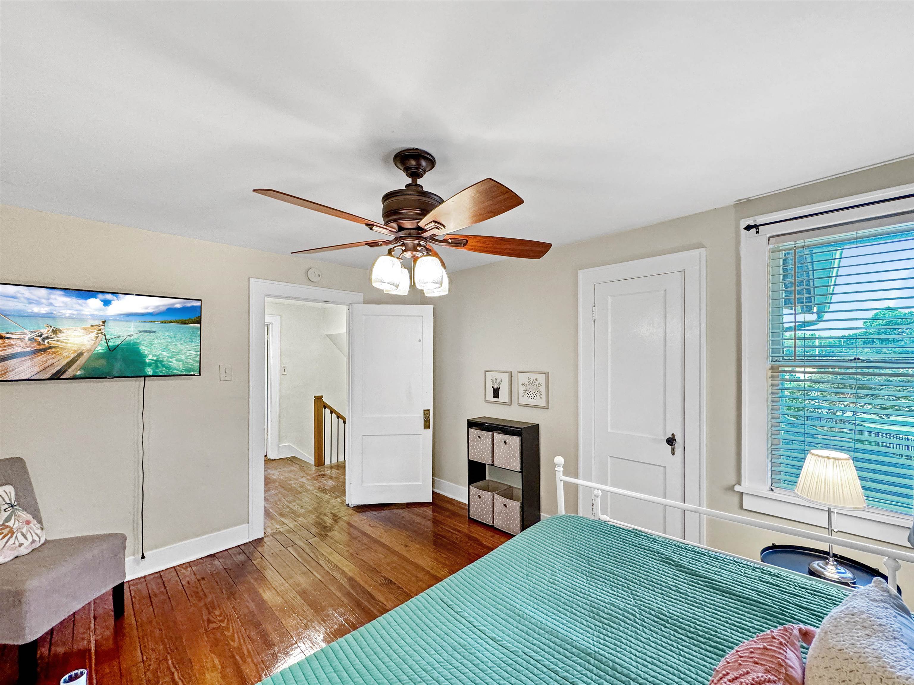 Bedroom with ceiling fan and hardwood / wood-style floors