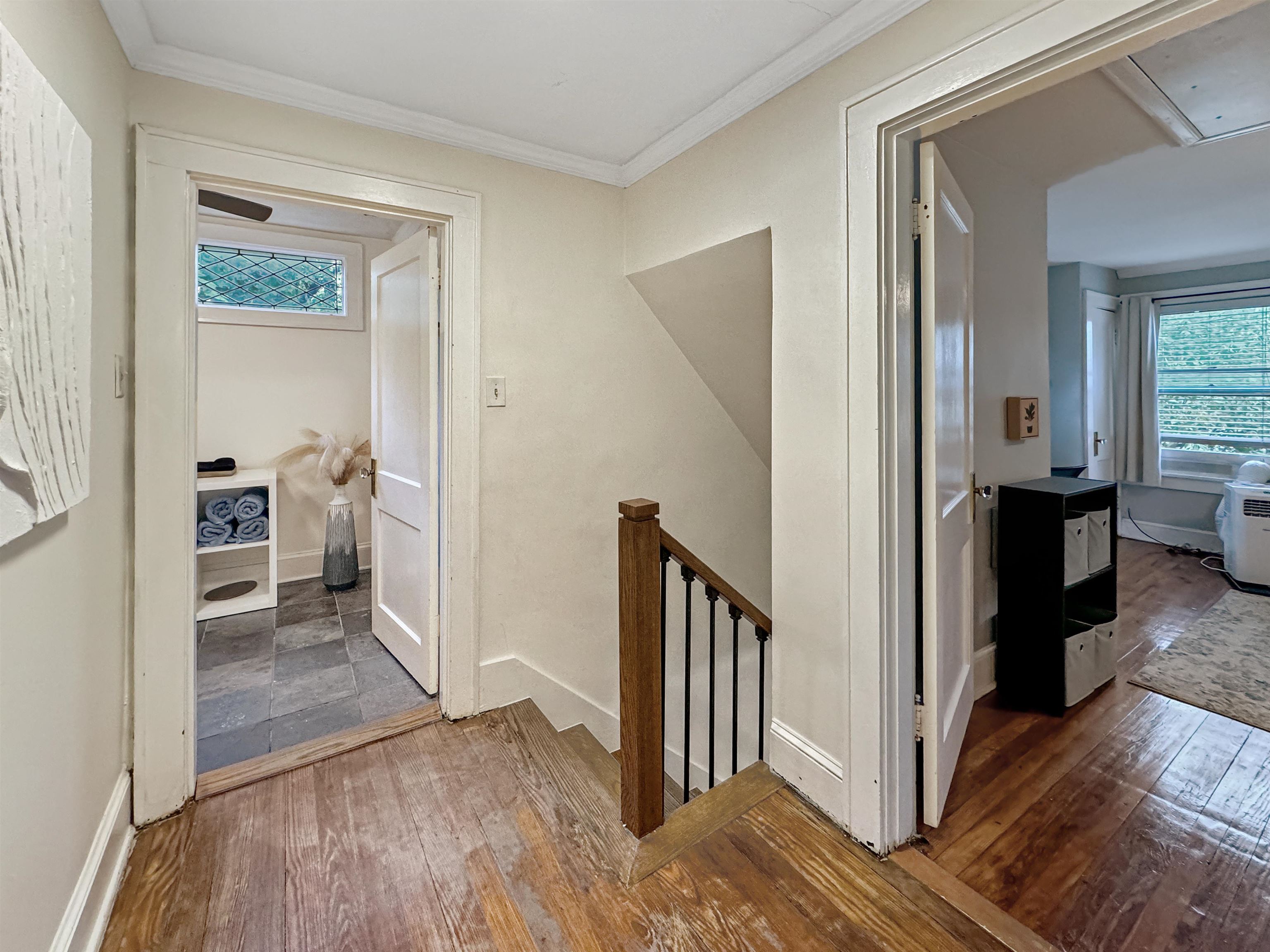 Corridor with ornamental molding and hardwood / wood-style flooring