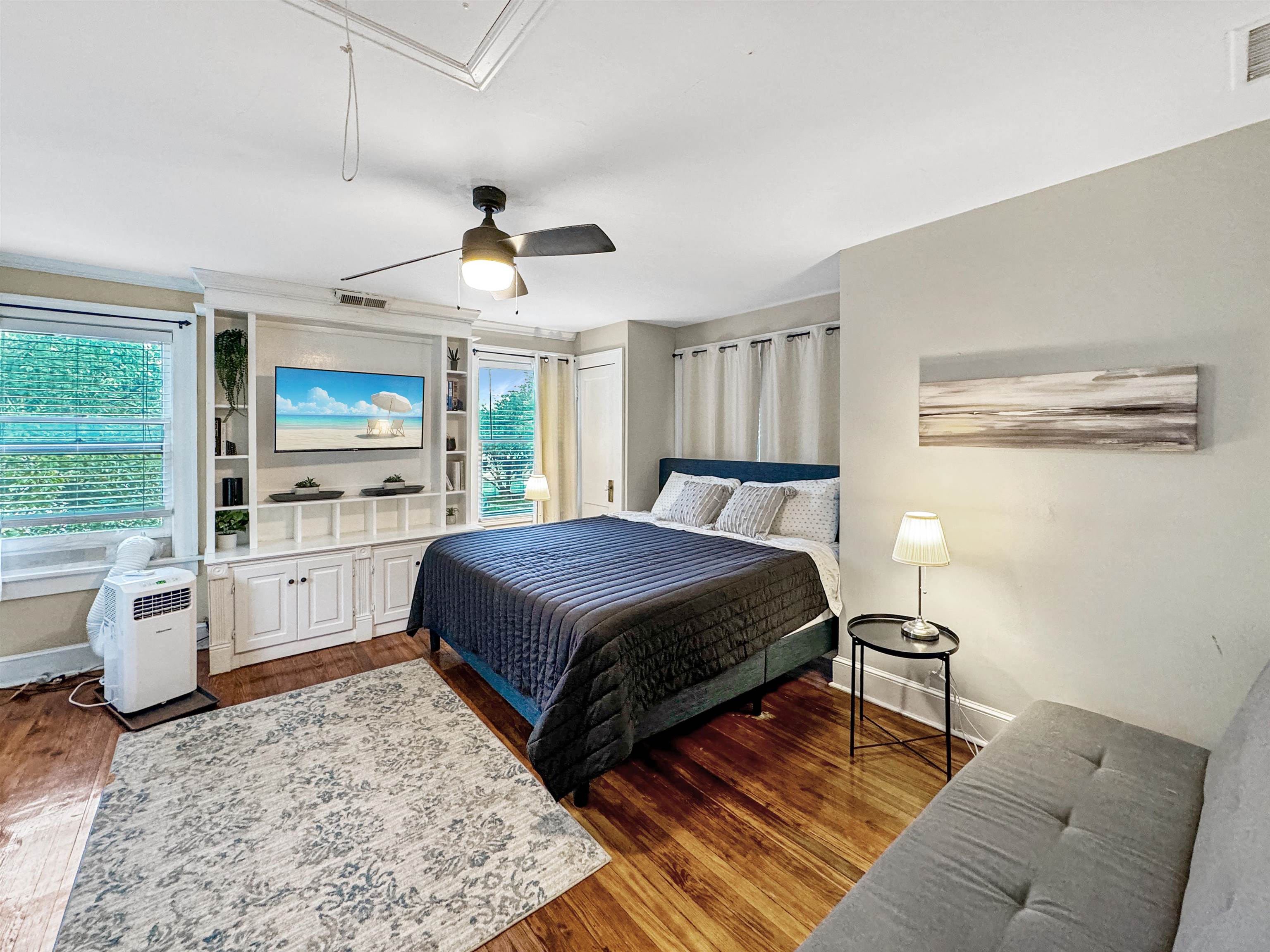 Bedroom with ceiling fan and dark hardwood / wood-style floors