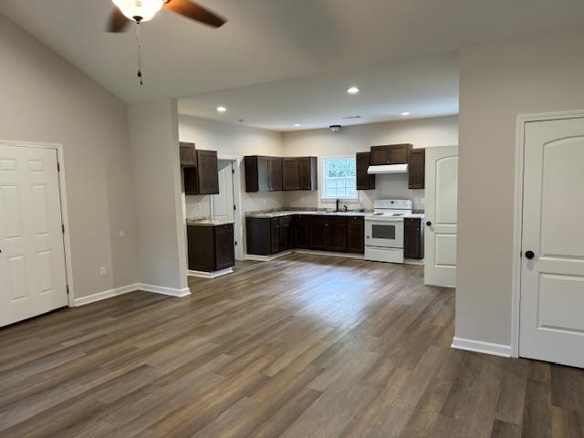 Kitchen with sink, white electric range oven, dark brown cabinetry, dark hardwood / wood-style flooring, and ceiling fan