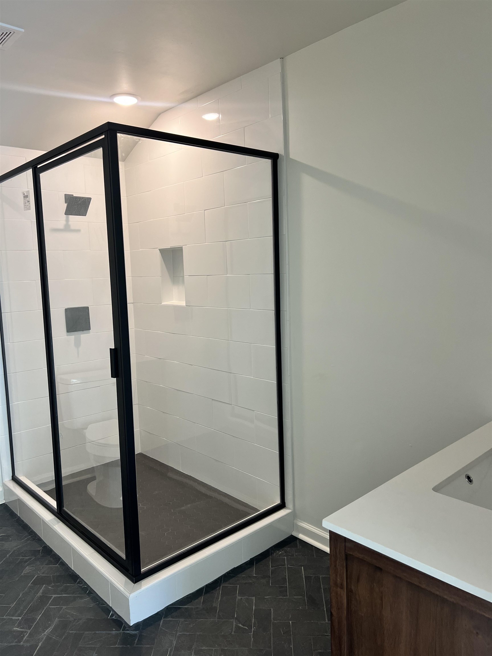 Bathroom featuring vanity, toilet, and an enclosed shower