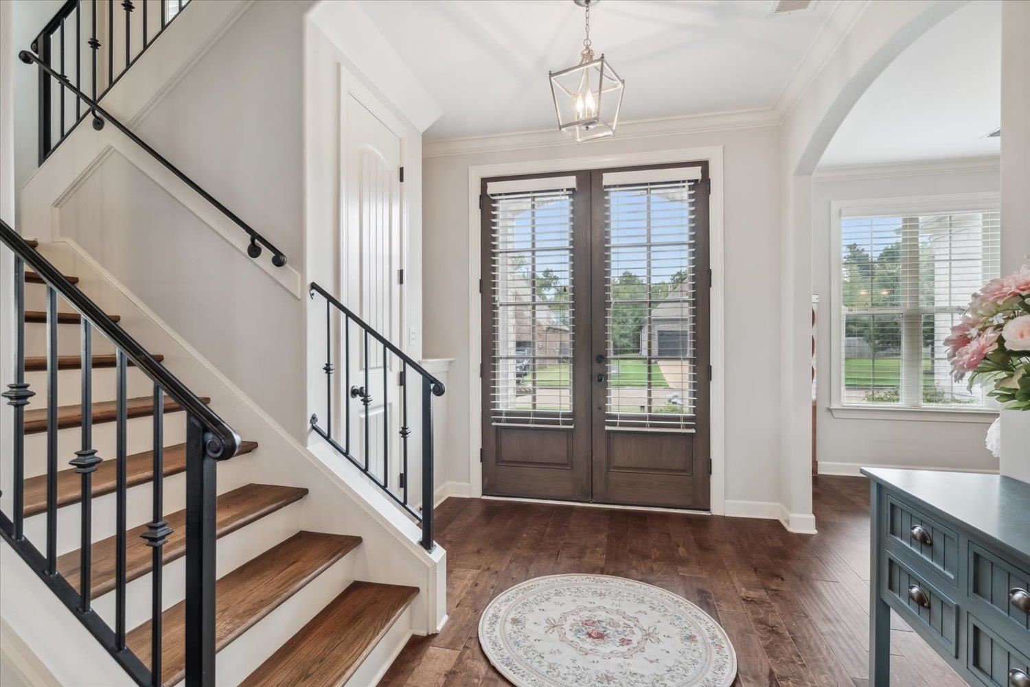 Entrance foyer featuring ornamental molding, a chandelier, and dark hardwood / wood-style flooring