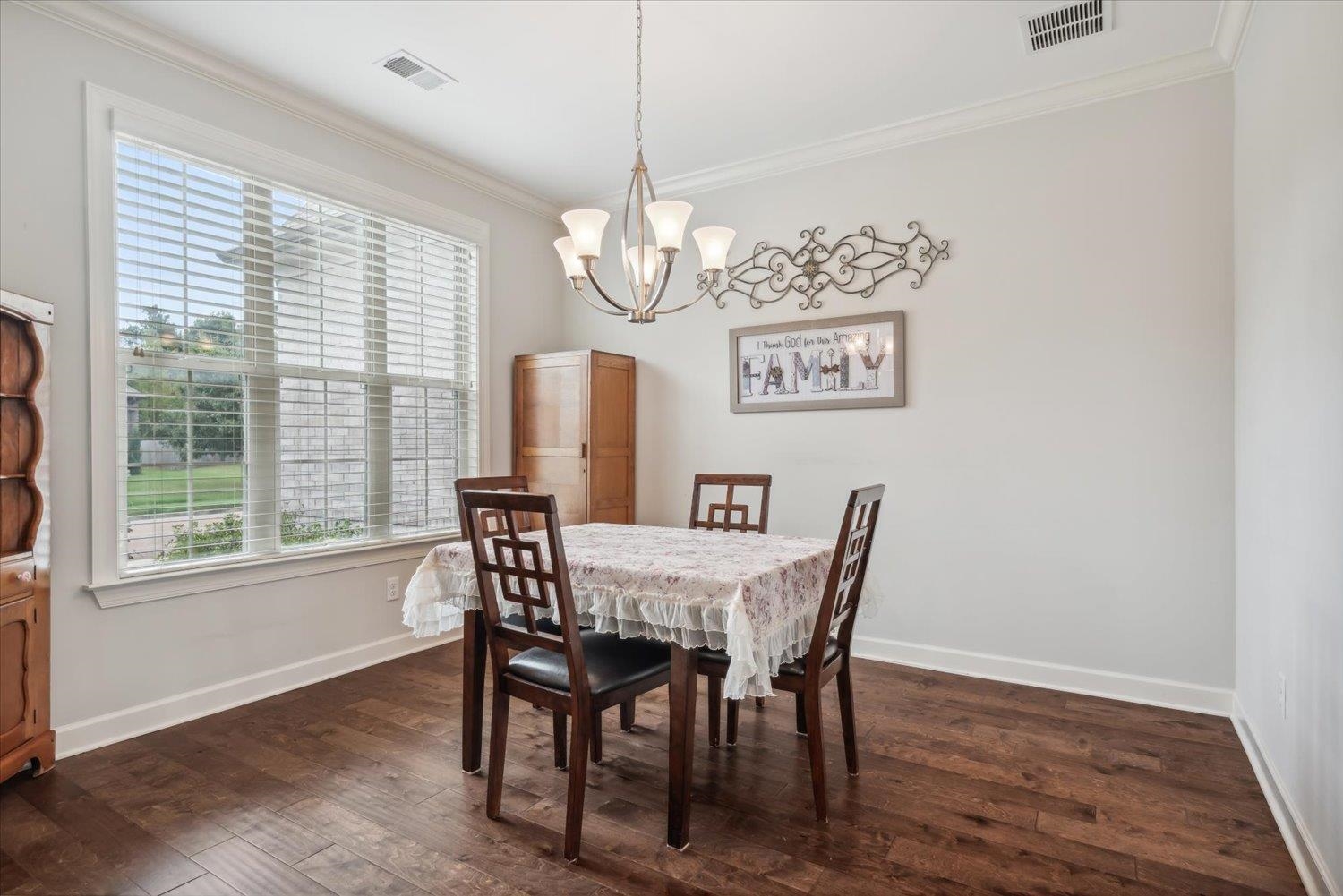 Dining space featuring crown molding, dark wood-type flooring, and plenty of natural light