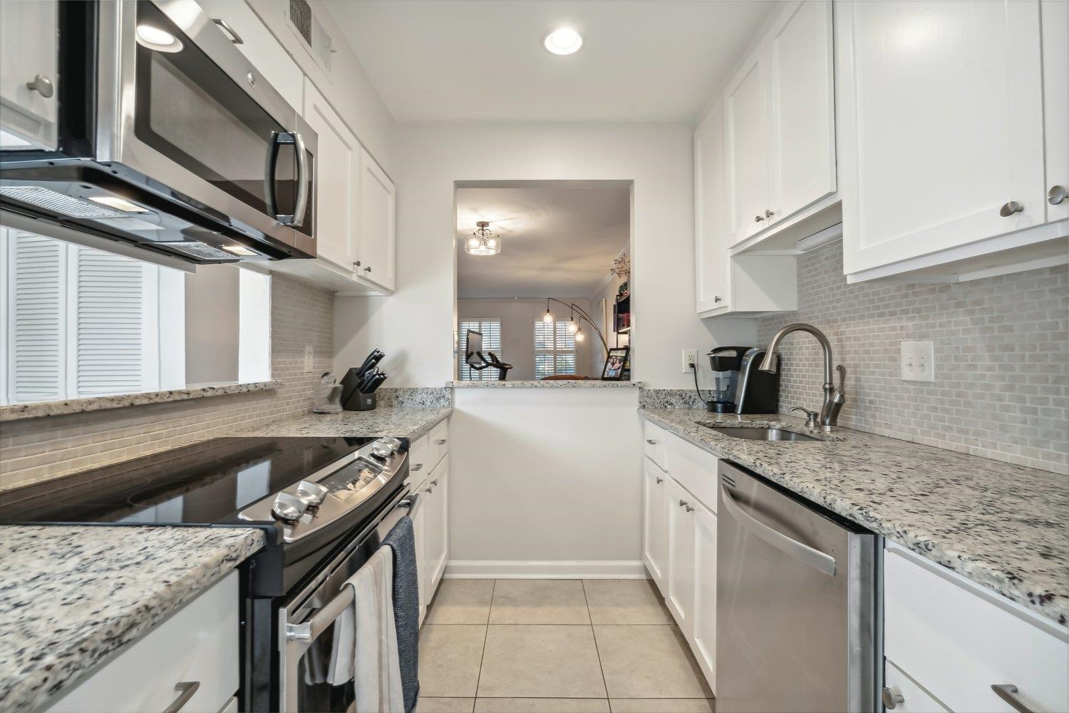 Kitchen with white cabinets, stainless steel appliances, and sink