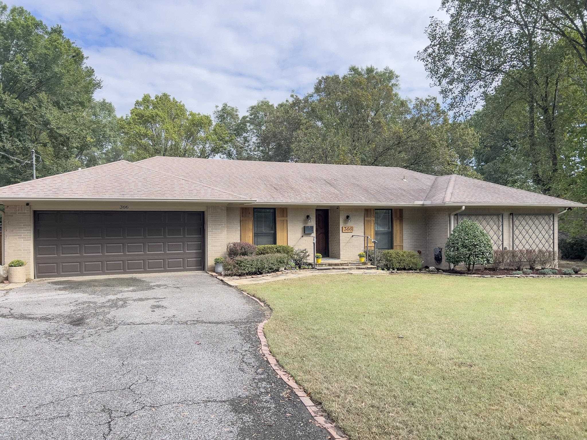 Ranch-style home featuring a front yard and a garage